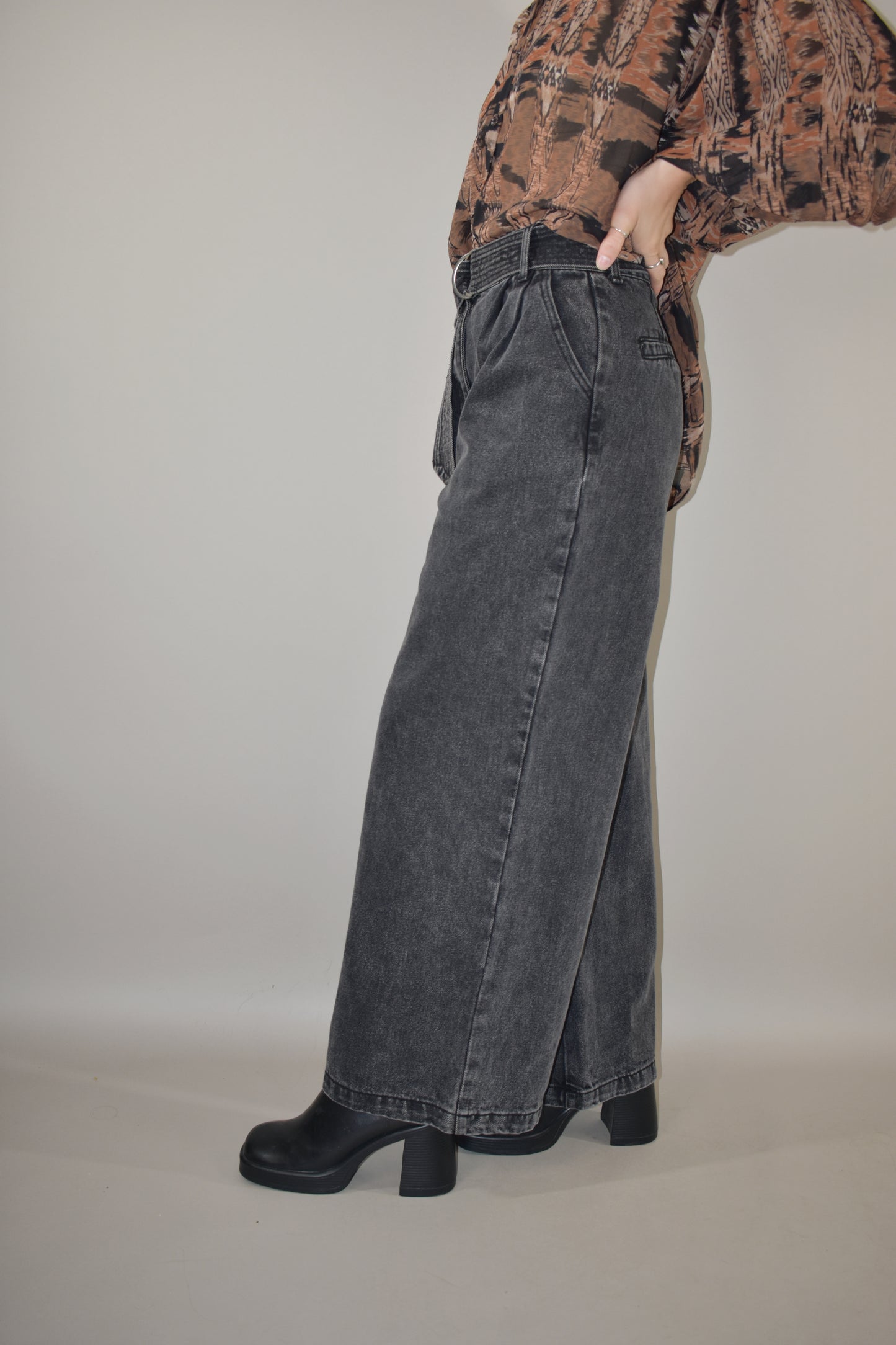 high waisted belted denim trousers wide leg with side pockets, front pleats ,zip and button enclosure, no holes or distressing, grey black wash