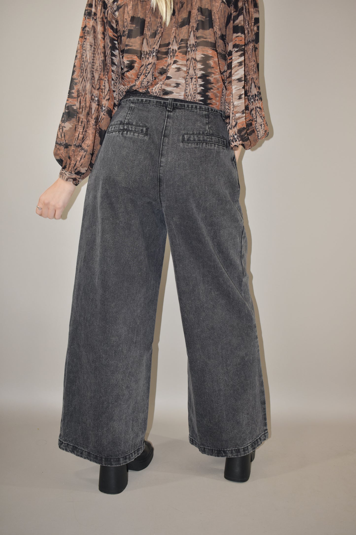 high waisted belted denim trousers wide leg with side pockets, front pleats ,zip and button enclosure, no holes or distressing, grey black wash