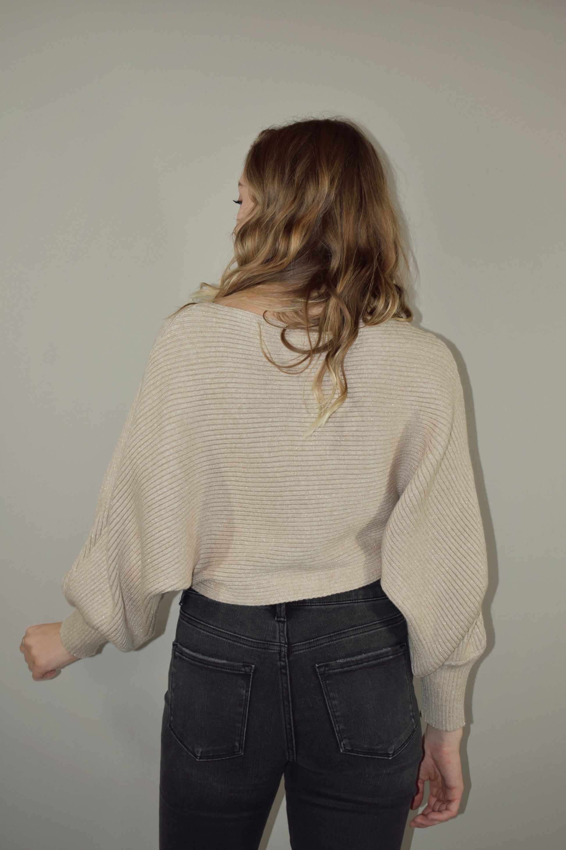 cropped sweater with a boat neckline and bubble sleeves with long ribbed cuffs. sparkles woven into the stretchy fabric. bat wing sleeve effect as well.