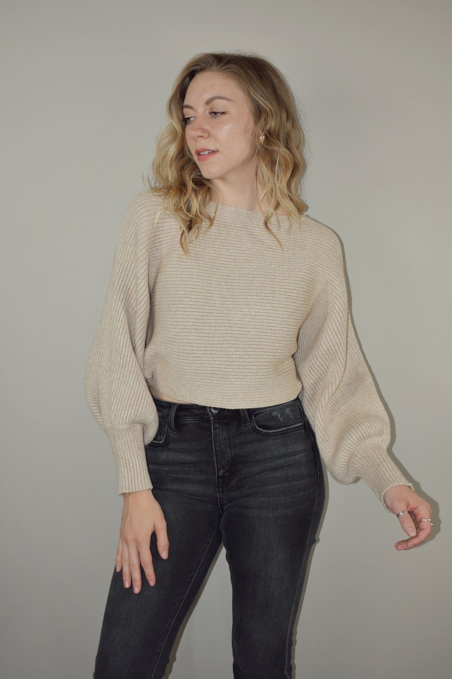 cropped sweater with a boat neckline and bubble sleeves with long ribbed cuffs. sparkles woven into the stretchy fabric. bat wing sleeve effect as well.