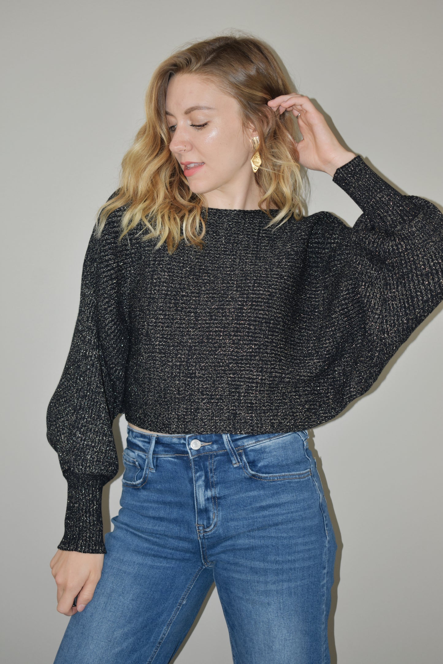 cropped sweater with a boat neckline and bubble sleeves with long ribbed cuffs. sparkles woven into the stretchy fabric. bat wing sleeve effect as well.