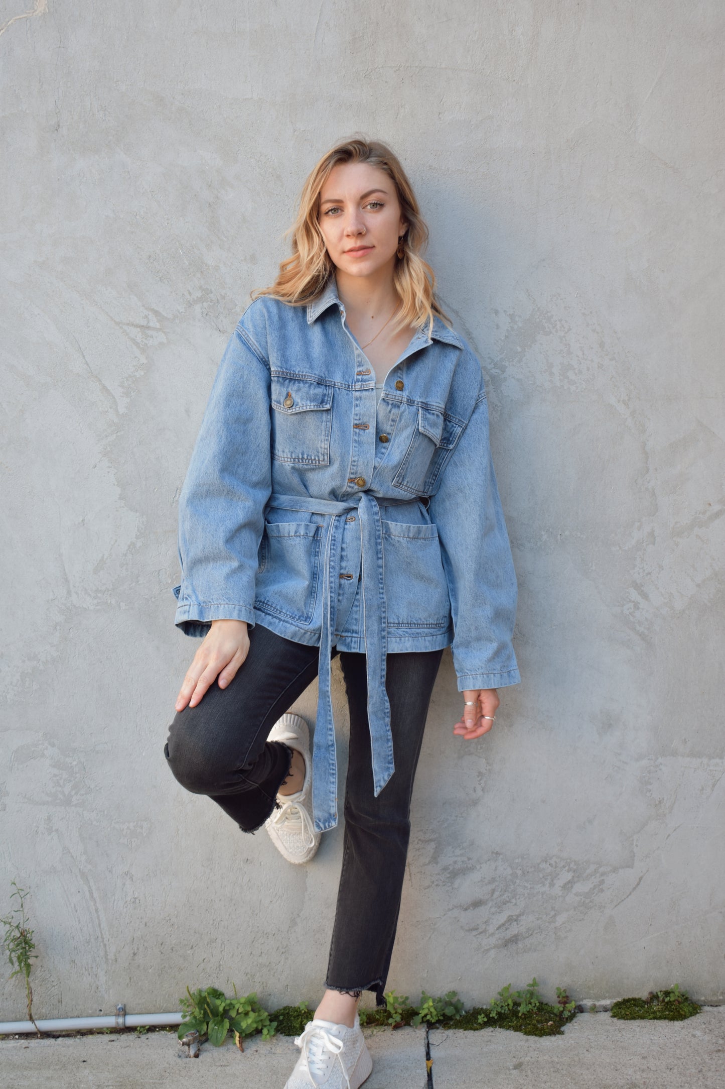 medium wash denim jacket with relaxed fit, tie at waist, deep patch pockets along with breast pockets with flap and button enclosure