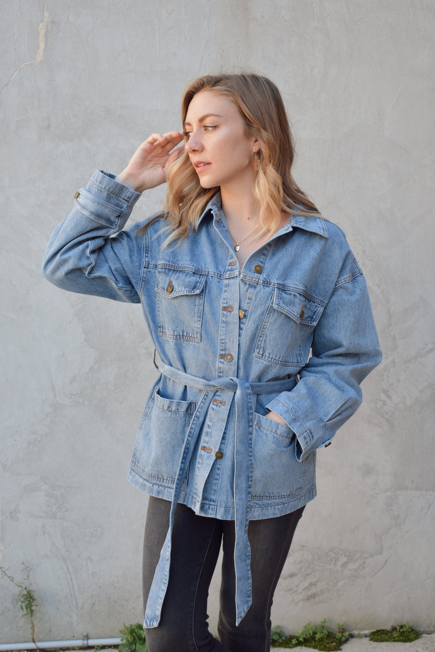 medium wash denim jacket with relaxed fit, tie at waist, deep patch pockets along with breast pockets with flap and button enclosure