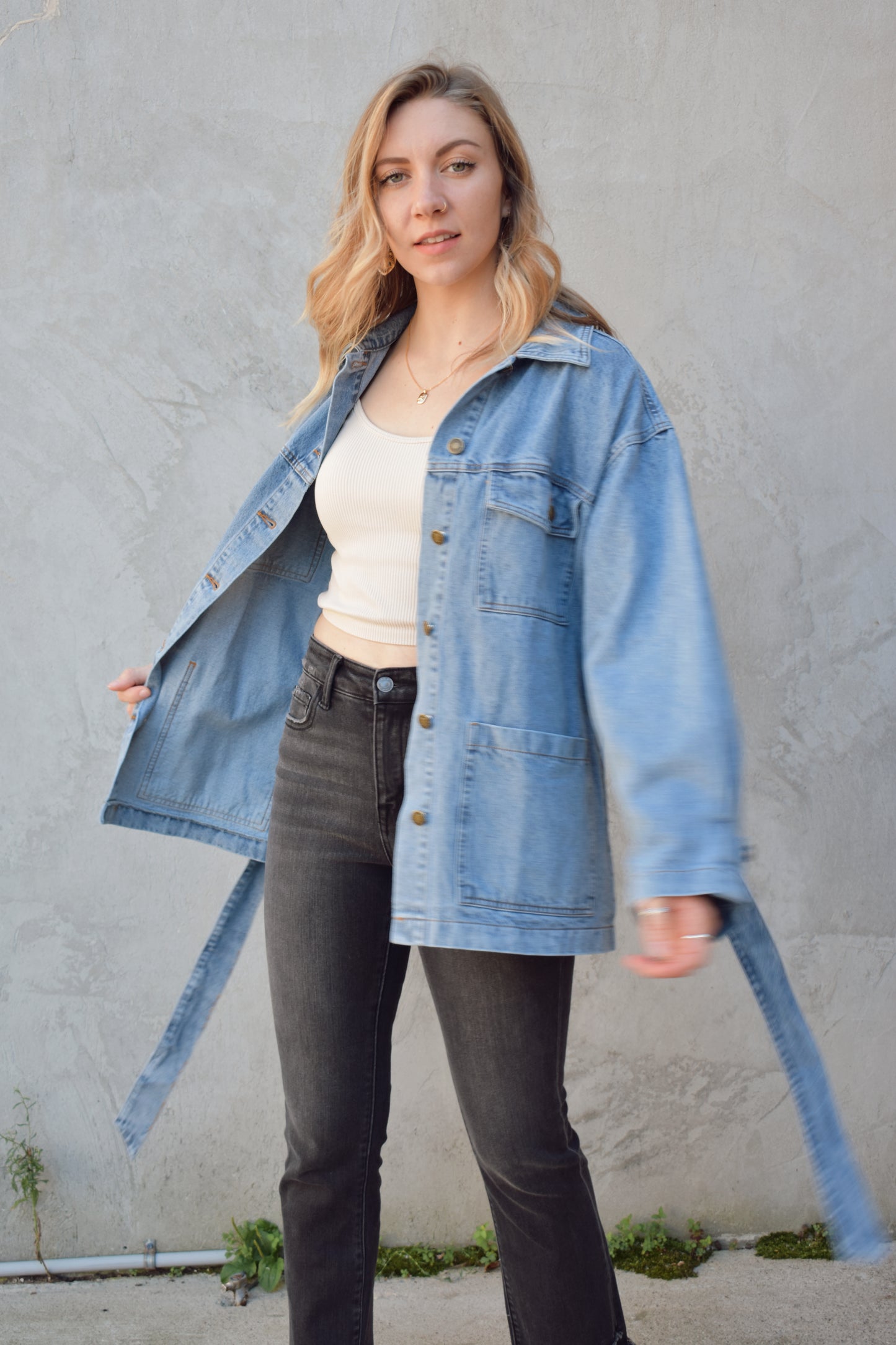 medium wash denim jacket with relaxed fit, tie at waist, deep patch pockets along with breast pockets with flap and button enclosure