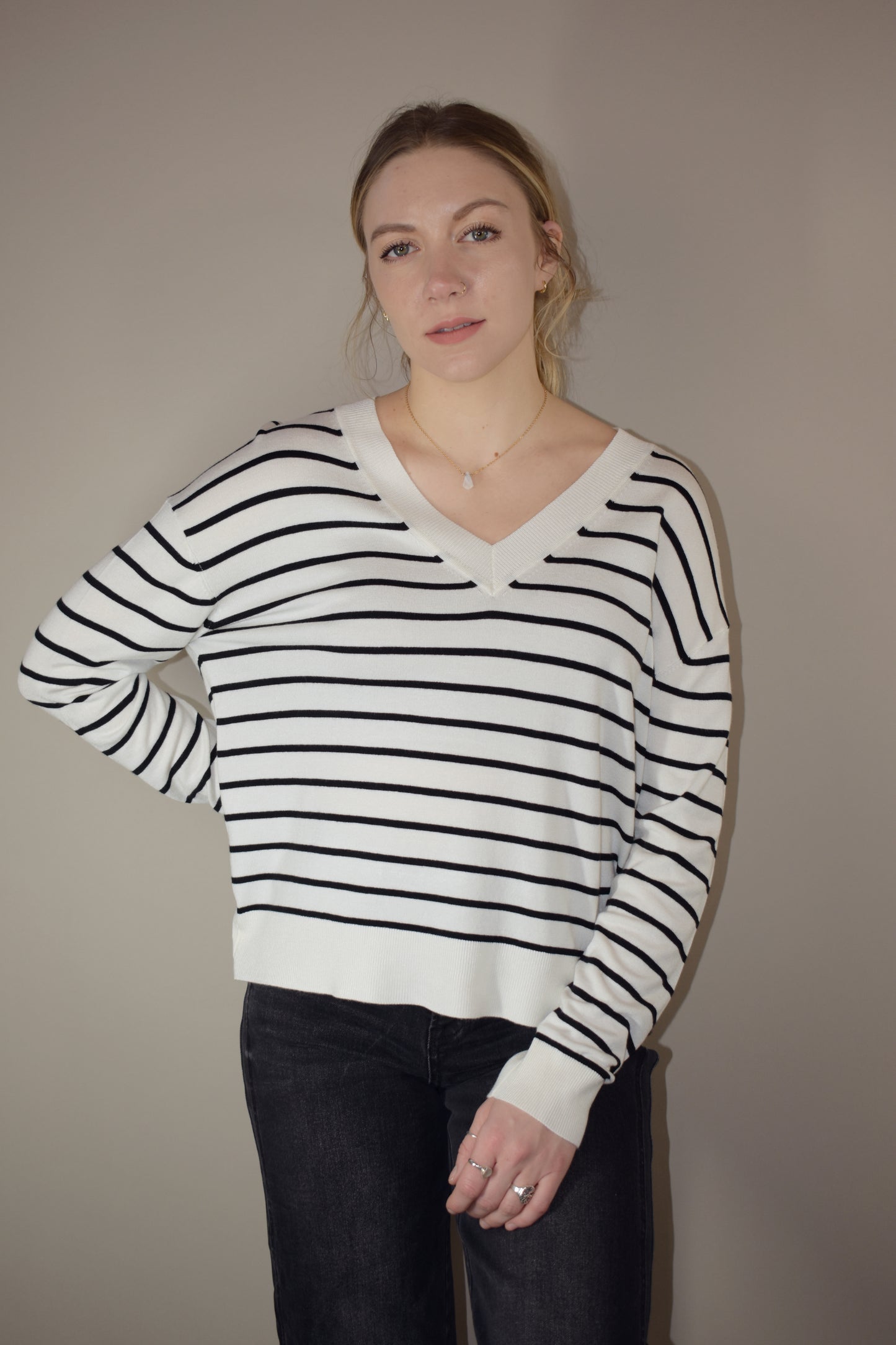 long sleeve full length v neck light weight sweater with horizontal black stripes, solid white hem, loose fit, drop shoulders, super soft.