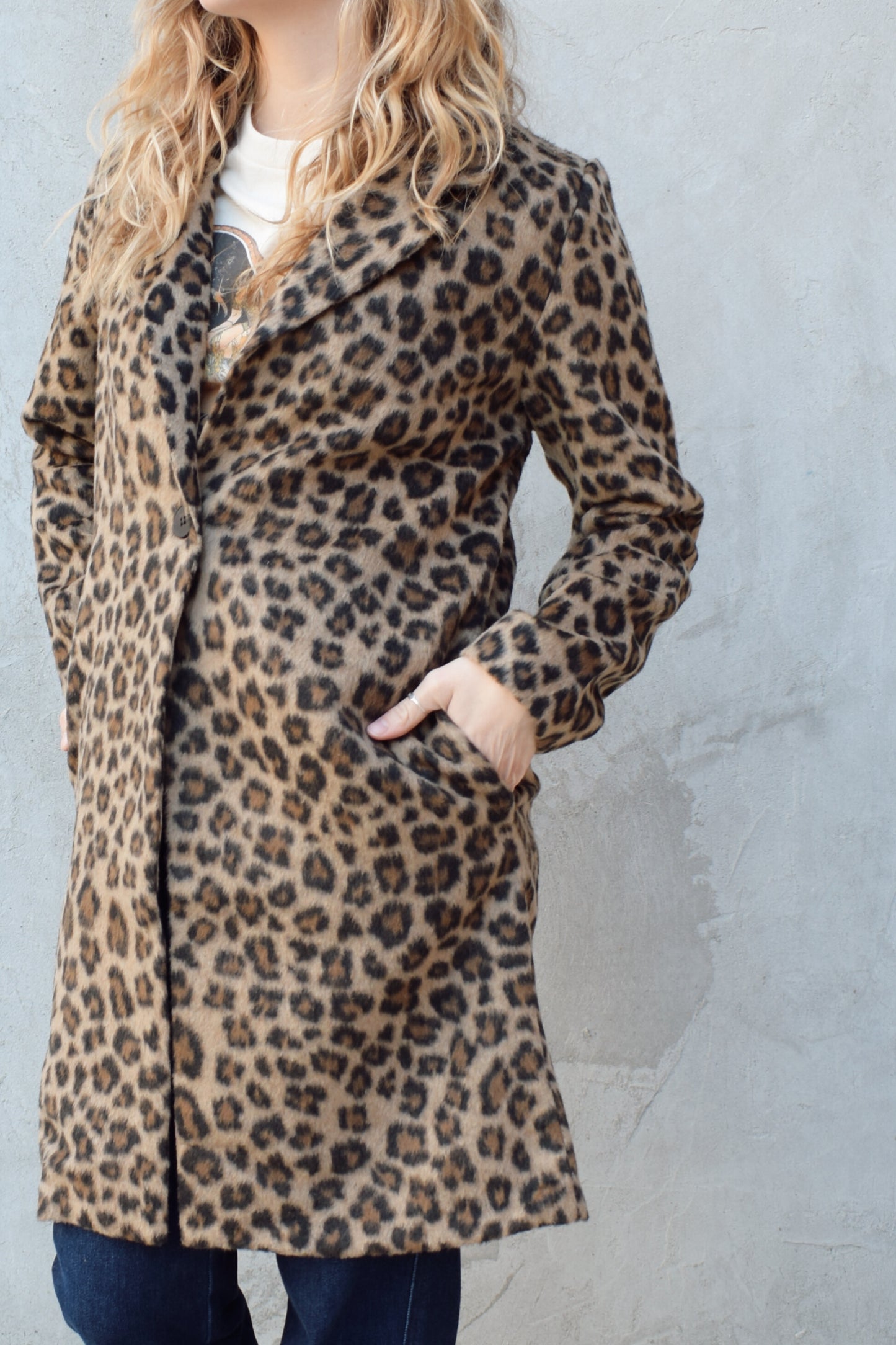 leopard print coat with collar and singular button enclosure has pockets hits just above the knee