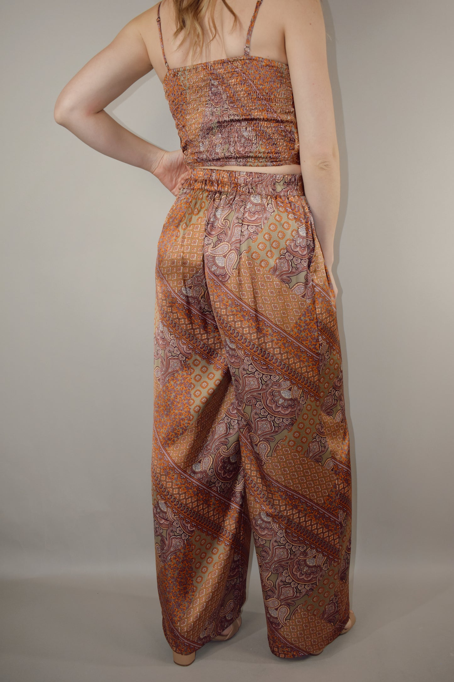 paisley printed satin high waisted full length wide leg pants with fitted band at waist and elastic stretch on back of band has pockets and pleats on front