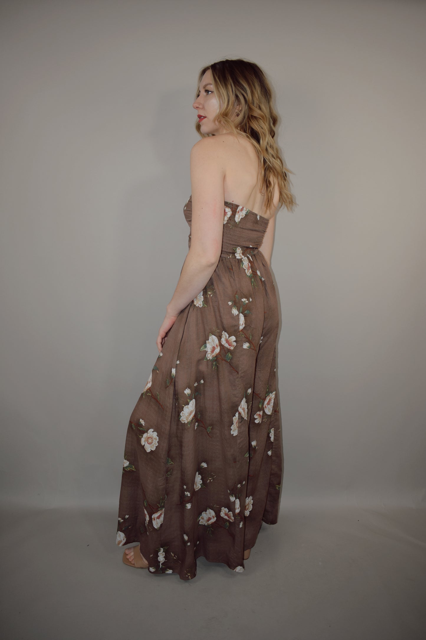 strapless wide leg flowy floral jumpsuit with tie and eyelet hole on front of bodice, has a elastic back panel on bodice full length, no pockets, is lined