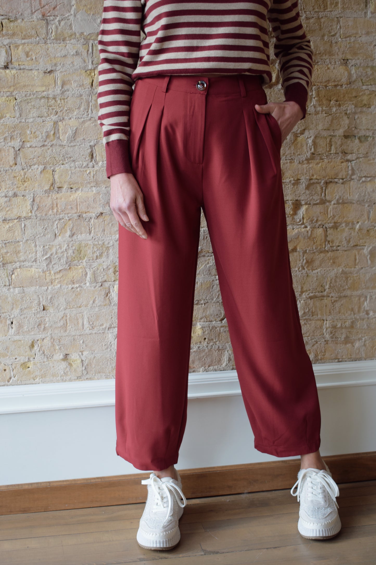 maroon pleated cropped trousers with zip and button enclosure, has pockets and beltloops, straight fit, high waisted, elastic band on back of waist