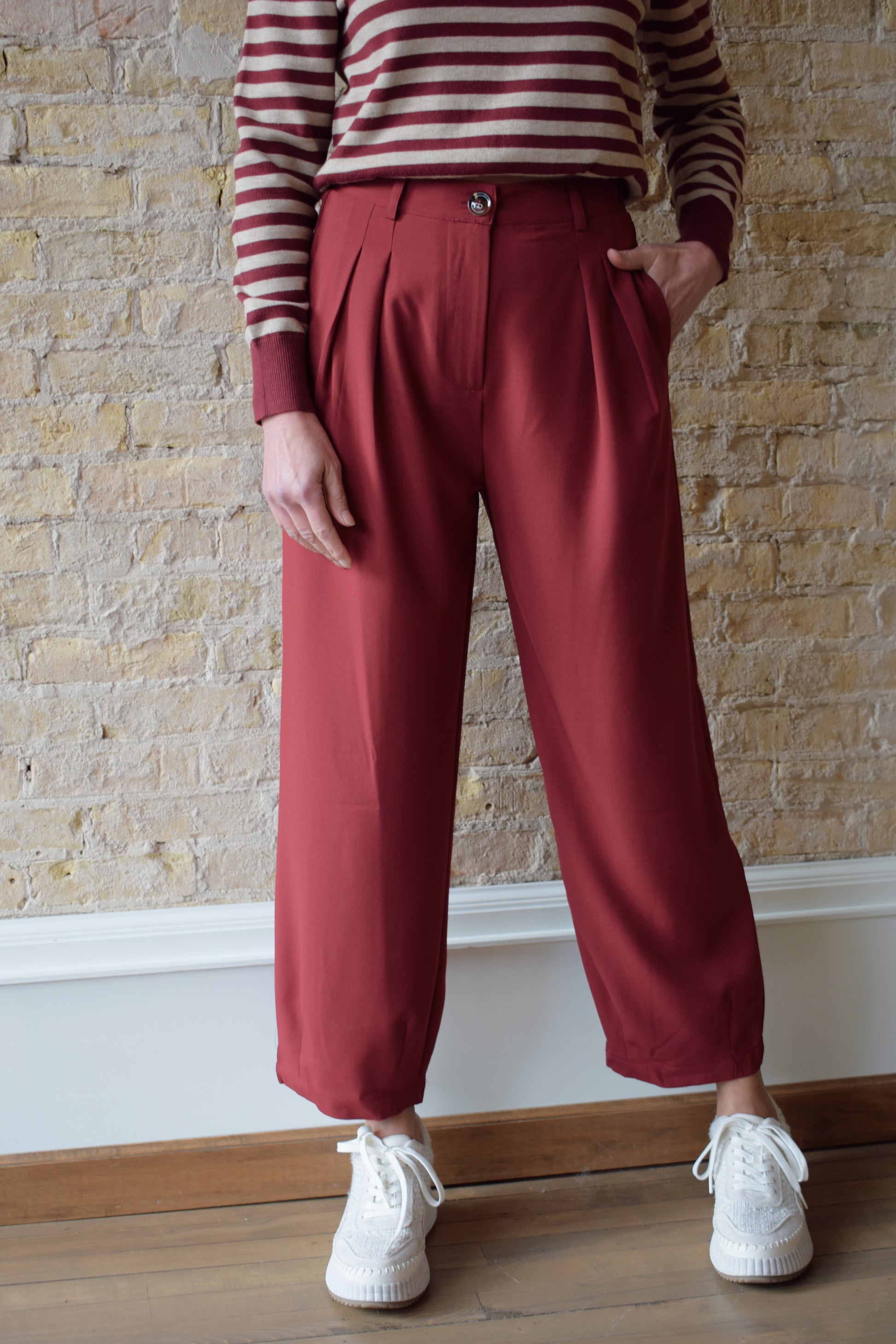 maroon pleated cropped trousers with zip and button enclosure, has pockets and beltloops, straight fit, high waisted, elastic band on back of waist
