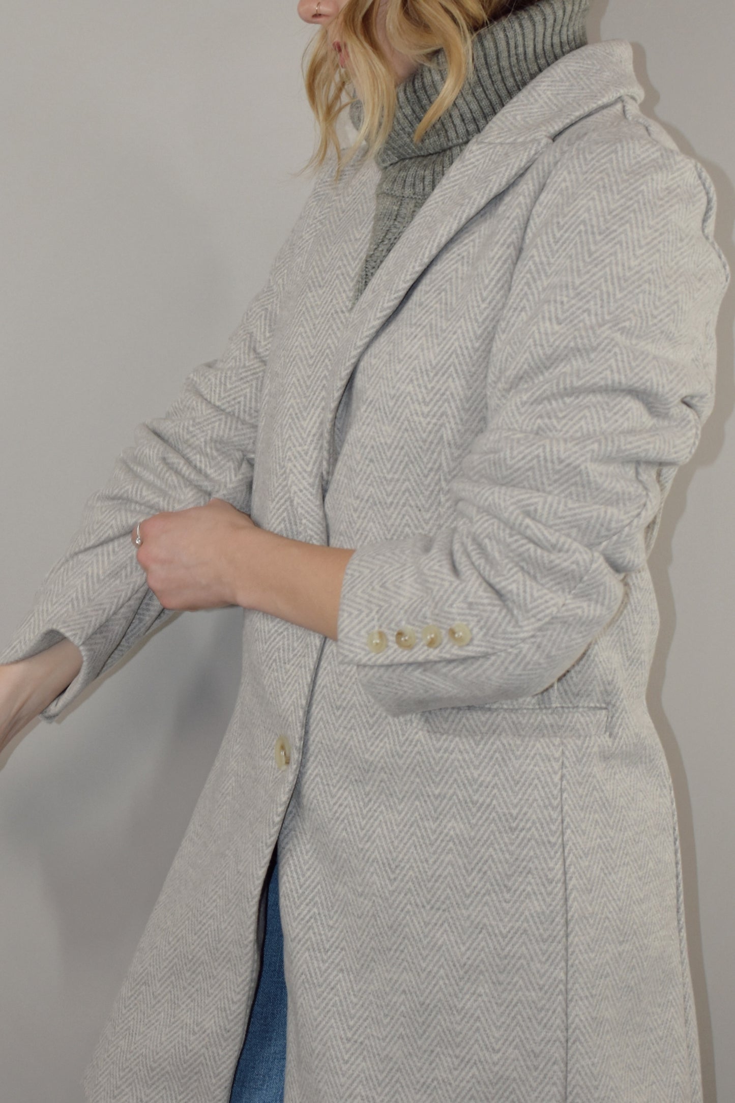 chevron longline blazer hits mid thigh with button detail along cuffs and two button enclosure on front, has pockets