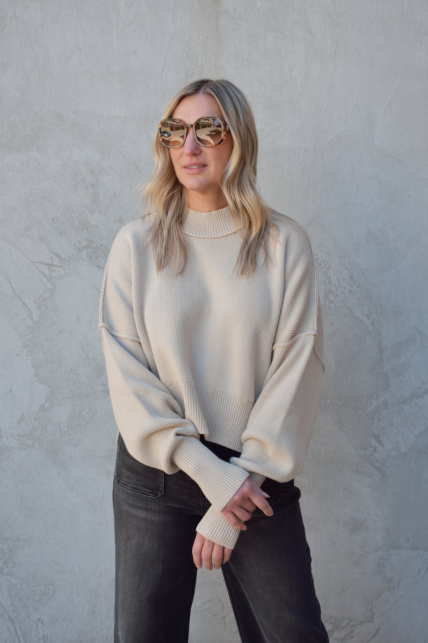 slouchy mock neck sweater with exposed seams, drop shoulders, slightly oversized and slightly cropped, wide ribbed cuffs and hem, split on side of hem