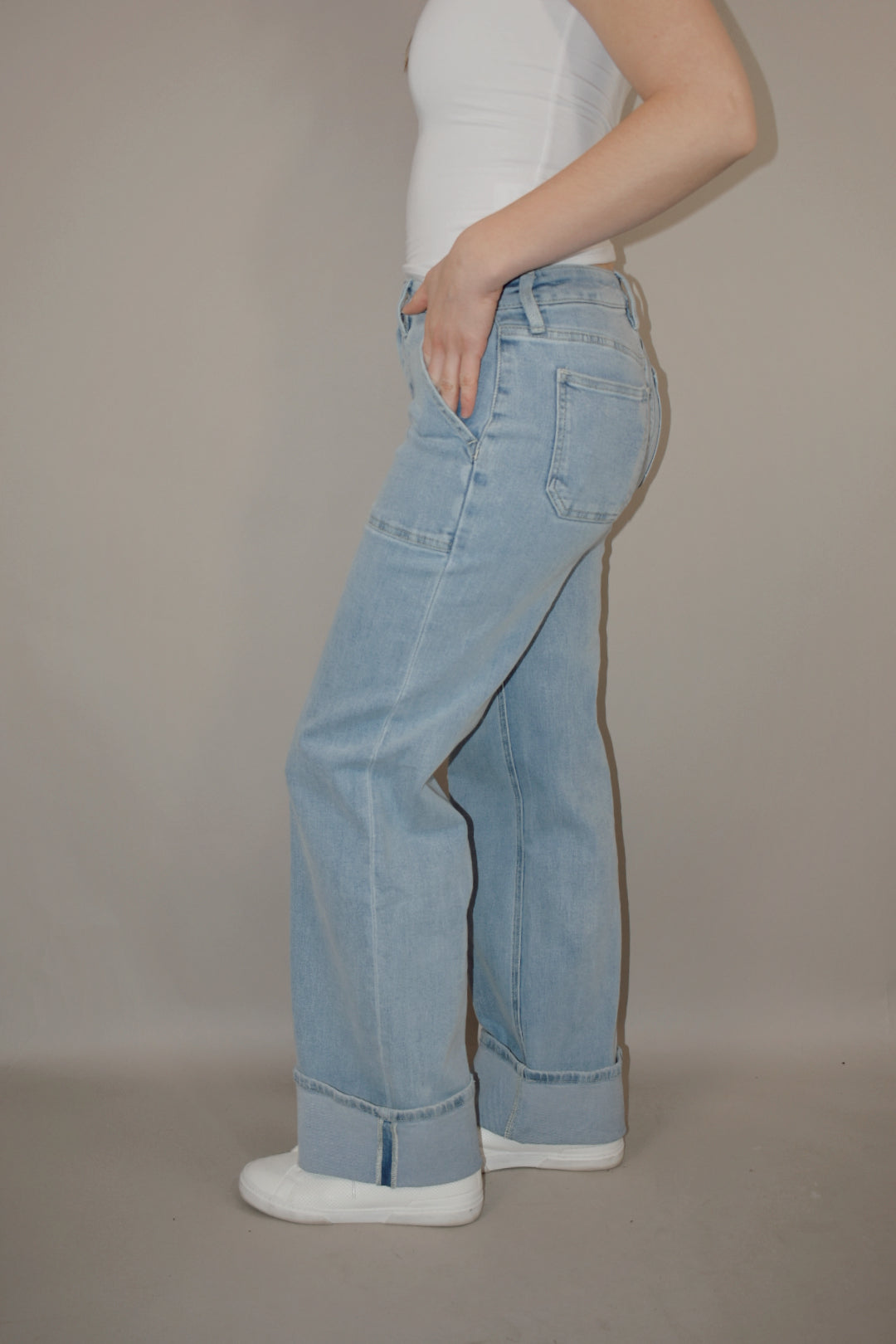 wide leg cuffed light wash stretch denim jeans with deep front patch style pockets and has a side carpenter pocket, no holes, zip and button enclosure, high rise.