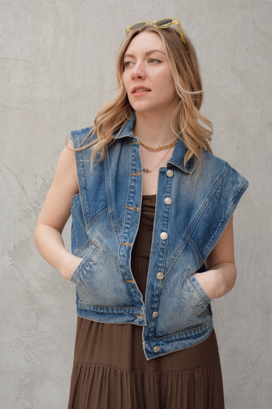denim full length vest medium wash with some lighter wash marks no holes seam details along front side and back has slit pockets front button enclosure and structured shoulders