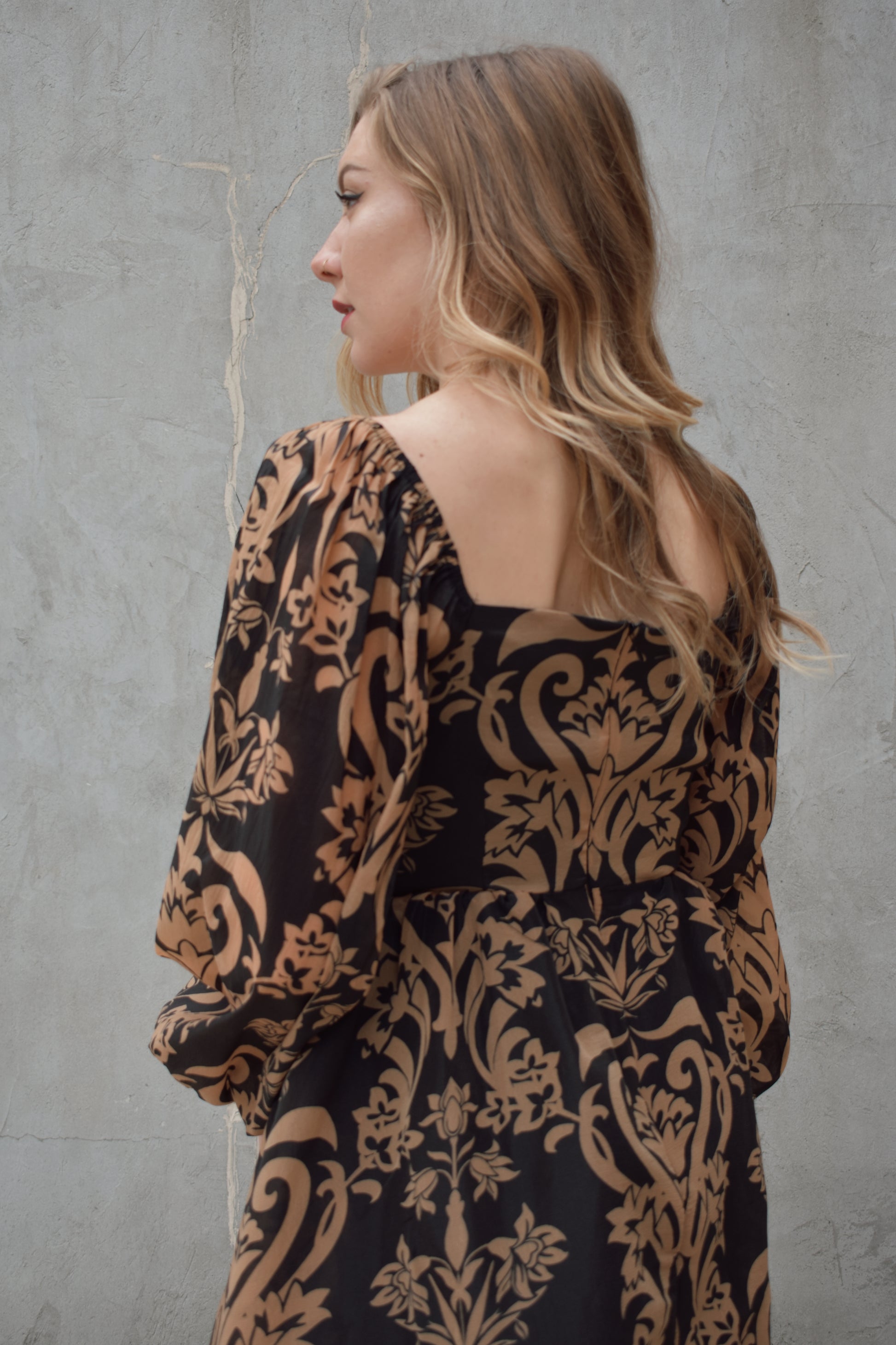 black and dark taupe dark bohemian print midi dress with square neckline front and back, balloon sleeves, flowy skirt, and zip back enclosure