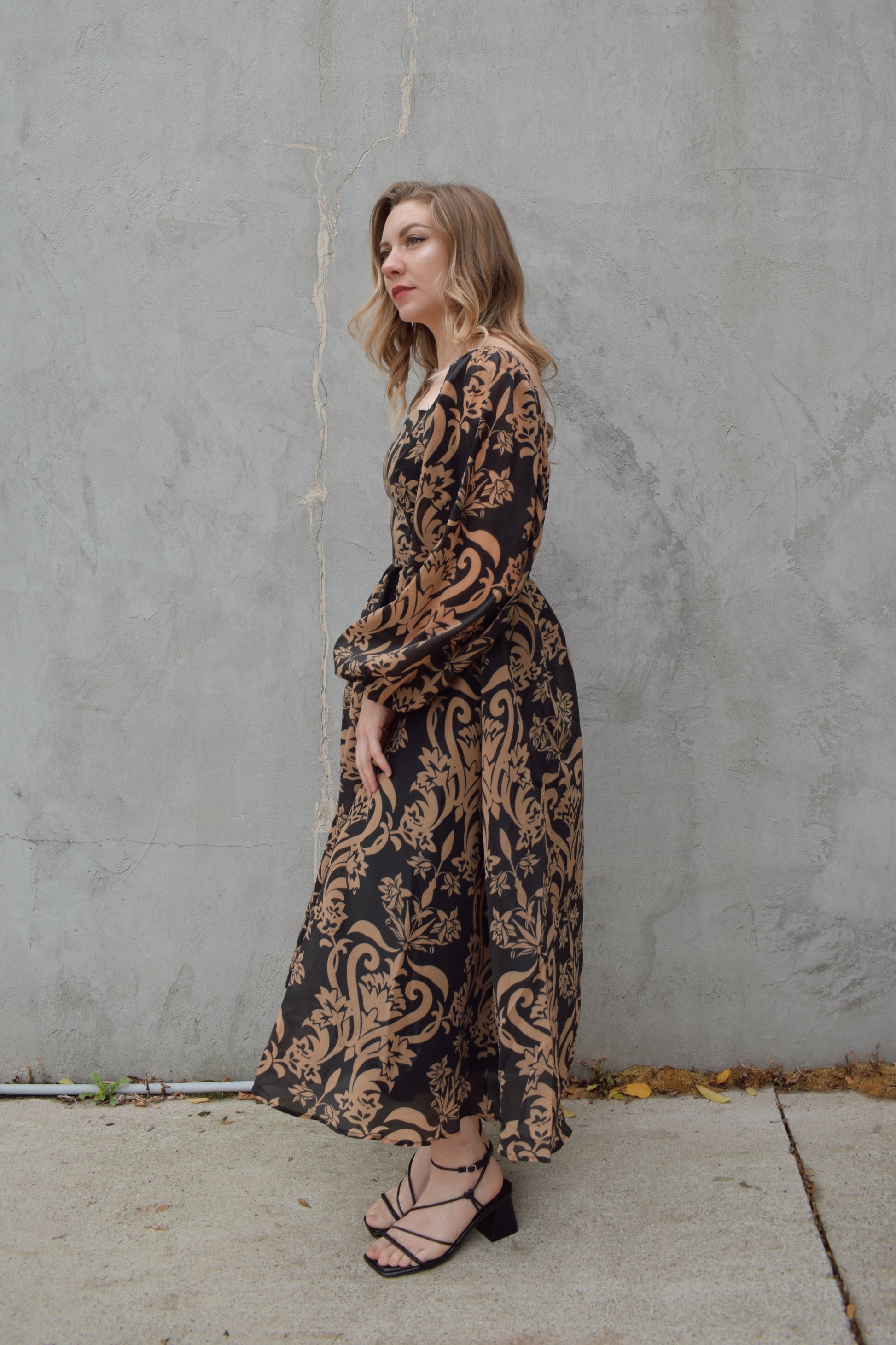 black and dark taupe dark bohemian print midi dress with square neckline front and back, balloon sleeves, flowy skirt, and zip back enclosure