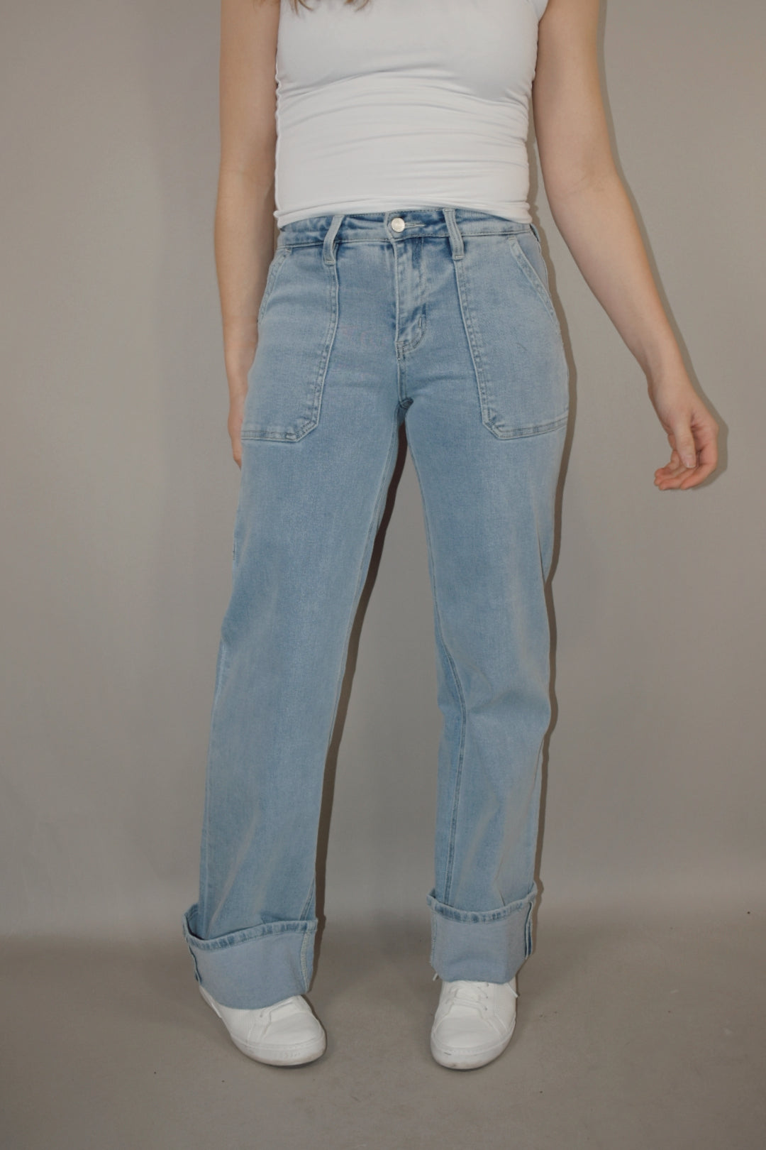 wide leg cuffed light wash stretch denim jeans with deep front patch style pockets and has a side carpenter pocket, no holes, zip and button enclosure, high rise.