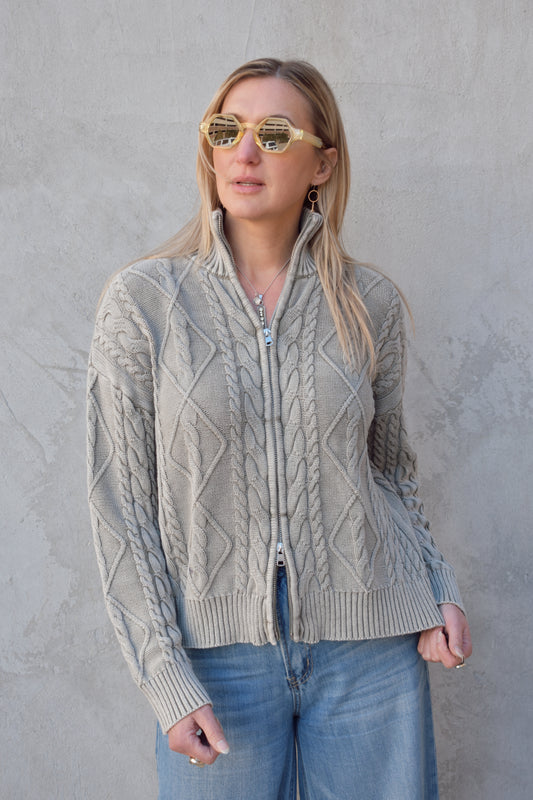 light gray twisted cable high neck sweater with front zip enclosure and it zips from both ways. ribbed cuffs, neck, and hem. drop shoulders.