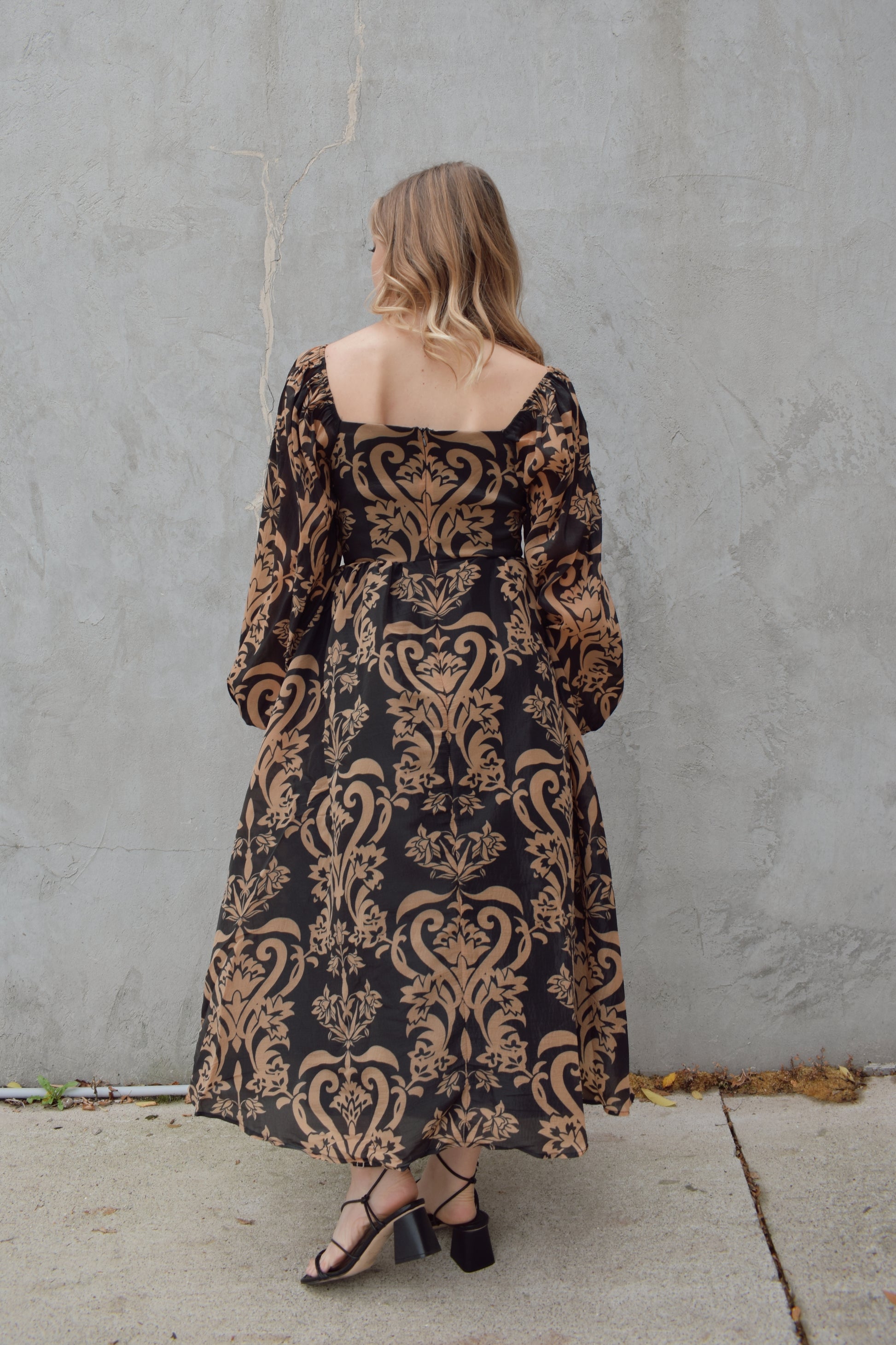 black and dark taupe dark bohemian print midi dress with square neckline front and back, balloon sleeves, flowy skirt, and zip back enclosure