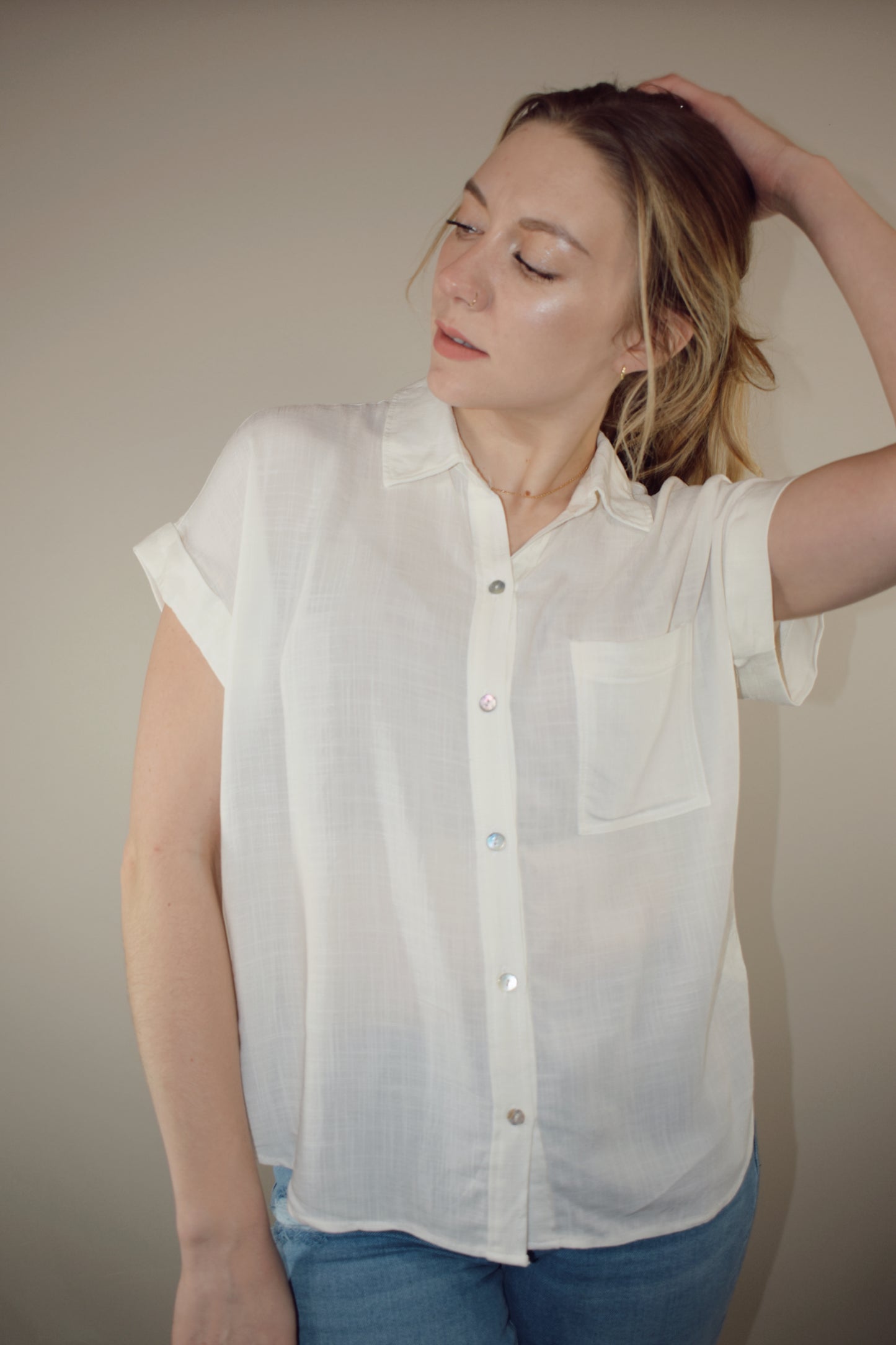 rayon white short sleeve collared button down with cuffed sleeves, one breast patch pocket, loose fit, full length, lightweight.