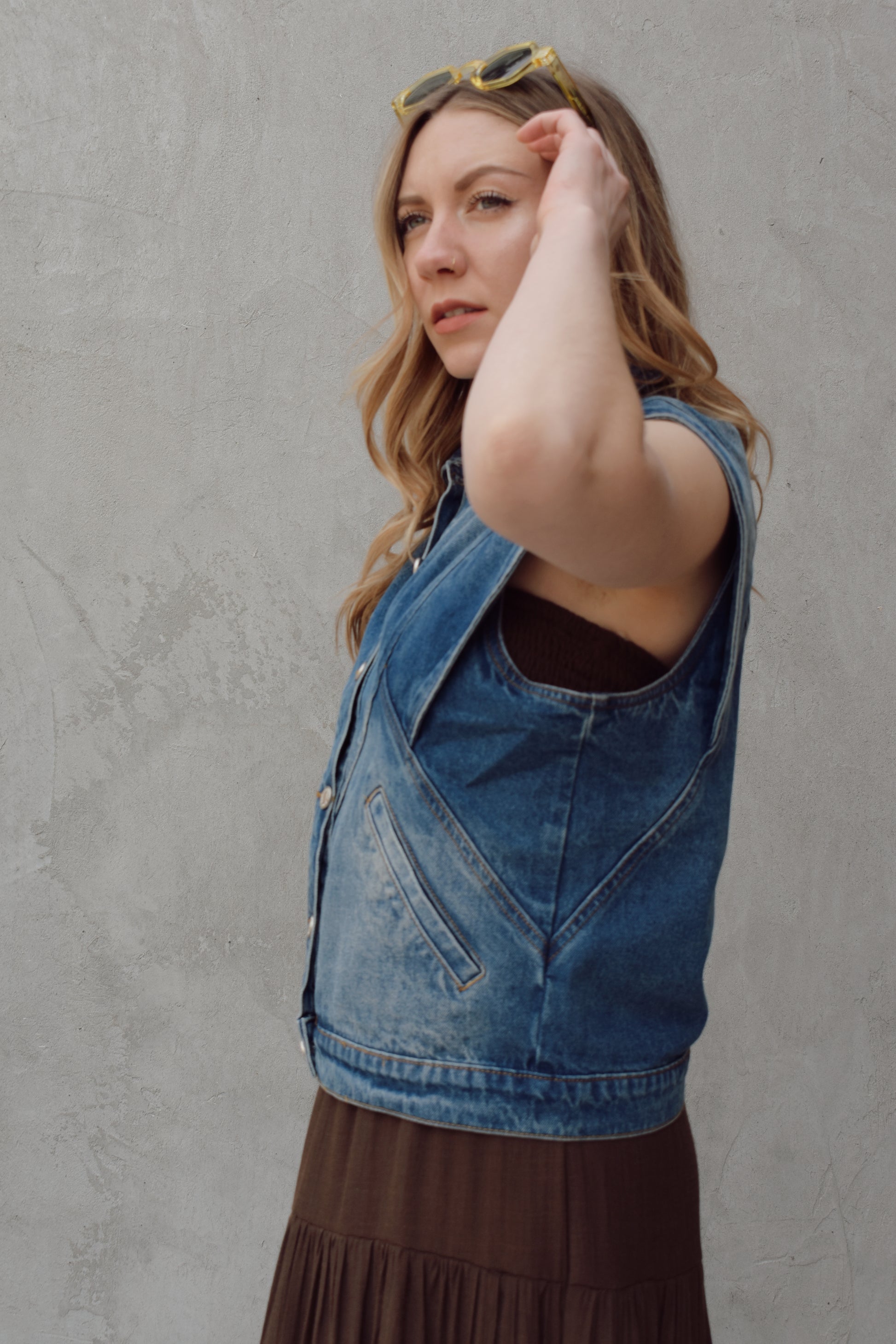 denim full length vest medium wash with some lighter wash marks no holes seam details along front side and back has slit pockets front button enclosure and structured shoulders