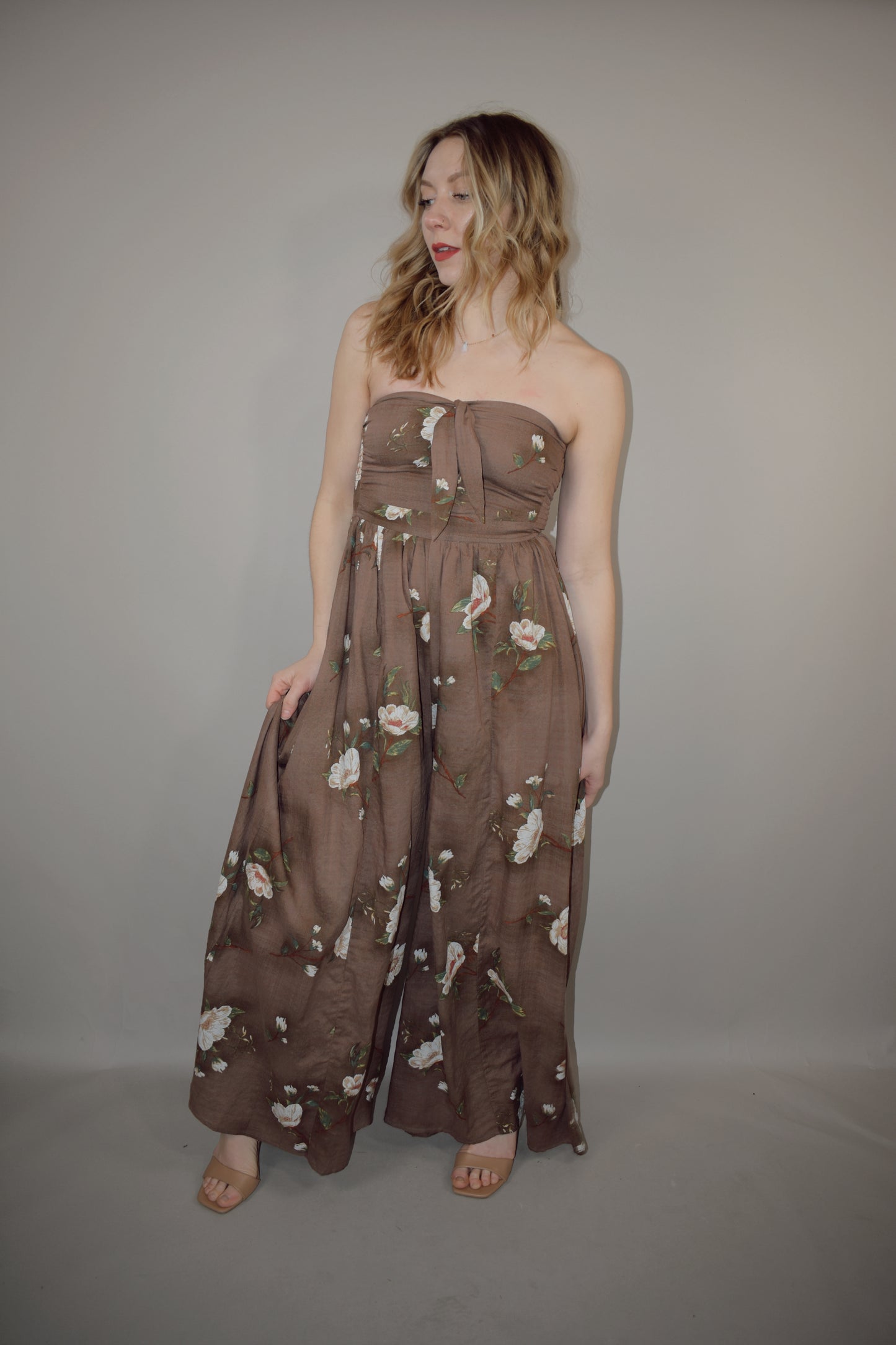 strapless wide leg flowy floral jumpsuit with tie and eyelet hole on front of bodice, has a elastic back panel on bodice full length, no pockets, is lined