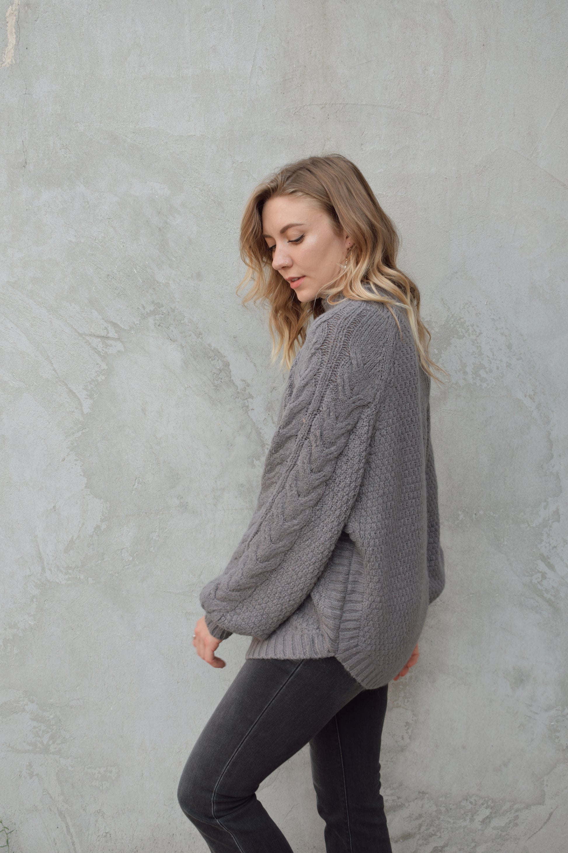 mock neck full length sweater with ribbed detailing around trim and chunky cable knit down the front and down the sleeves. rounded hem, slouchy sleeves.