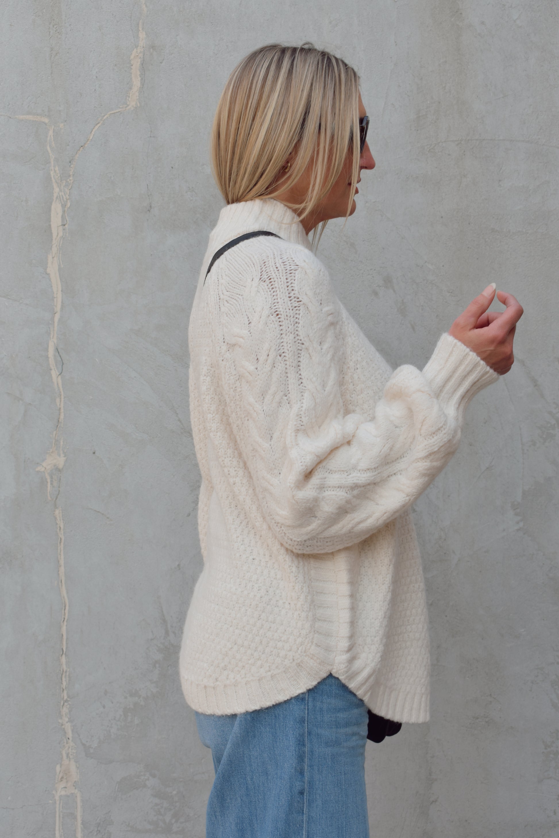 mock neck full length sweater with ribbed detailing around trim and chunky cable knit down the front and down the sleeves. rounded hem, slouchy sleeves.