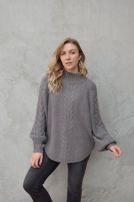 mock neck full length sweater with ribbed detailing around trim and chunky cable knit down the front and down the sleeves. rounded hem, slouchy sleeves.