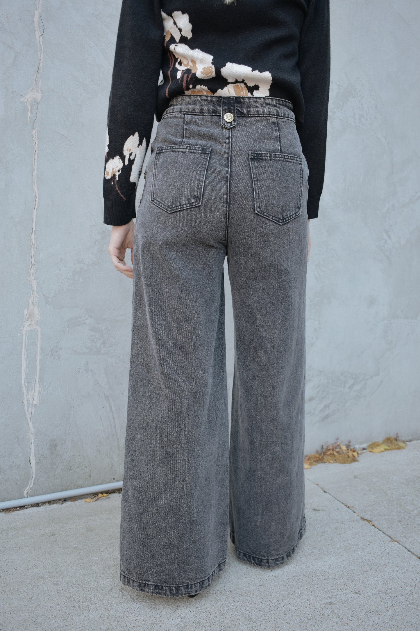 wide leg jeans - black wash - no holes - gold sailor buttons along front side pockets and on button on back belt loop fastening it. zip and button enclosure. high waisted. 