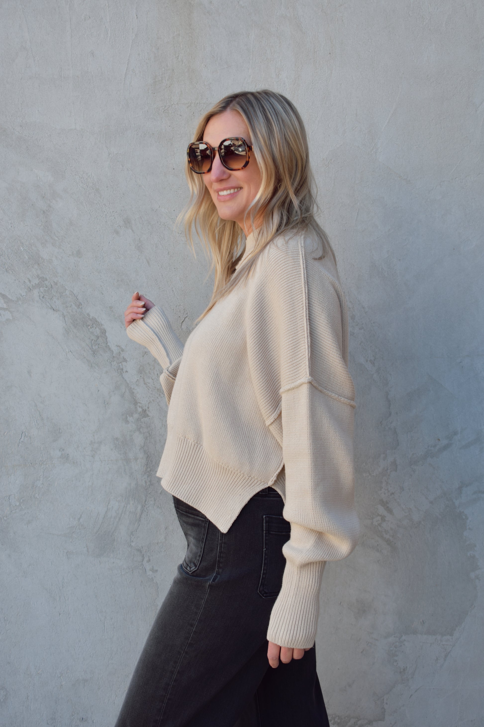 slouchy mock neck sweater with exposed seams, drop shoulders, slightly oversized and slightly cropped, wide ribbed cuffs and hem, split on side of hem