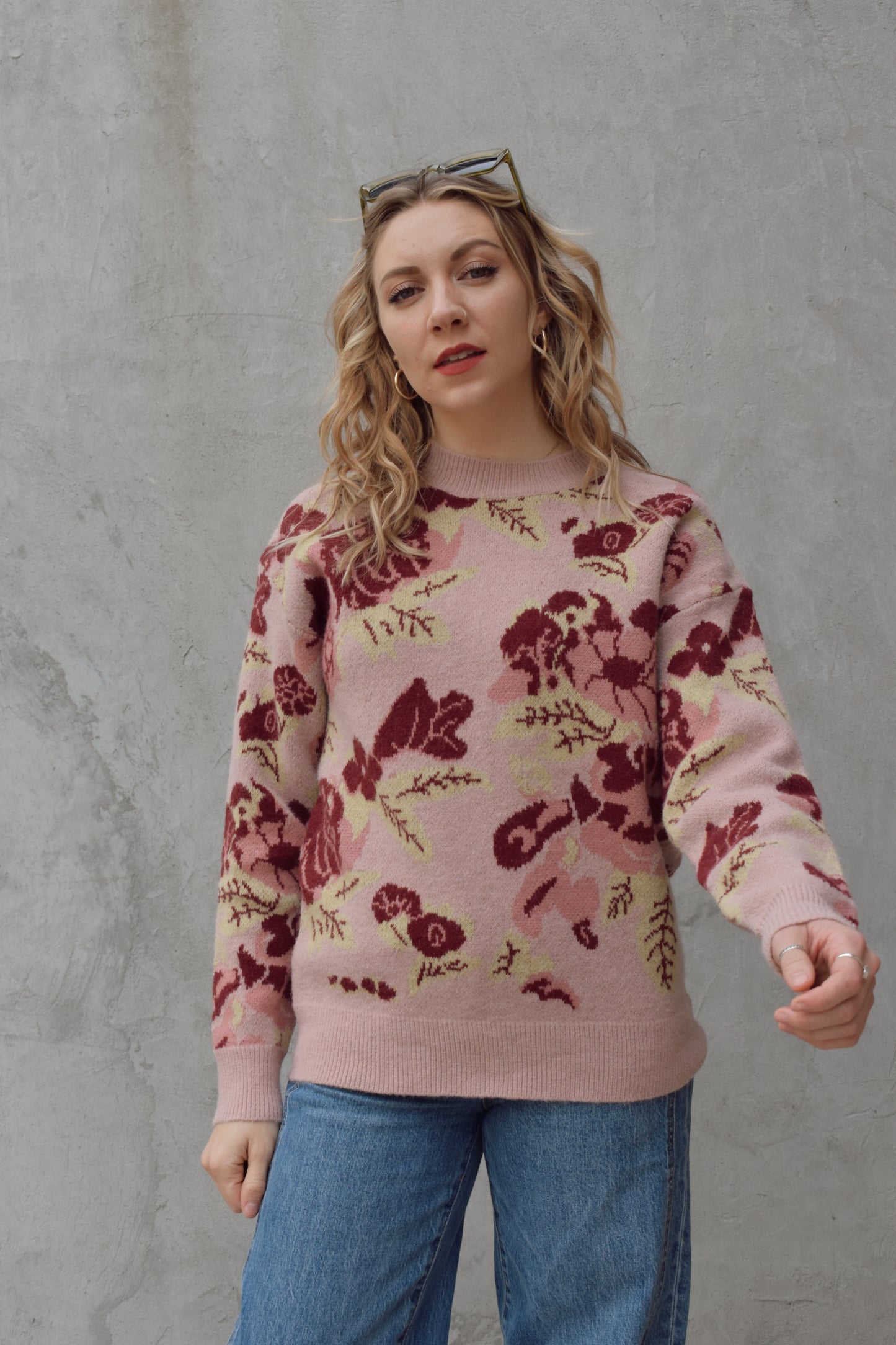 crew neck sweater full length relaxed fit drop shoulder with dusty rose background and floral and leaf design in shades of red pink and light green 