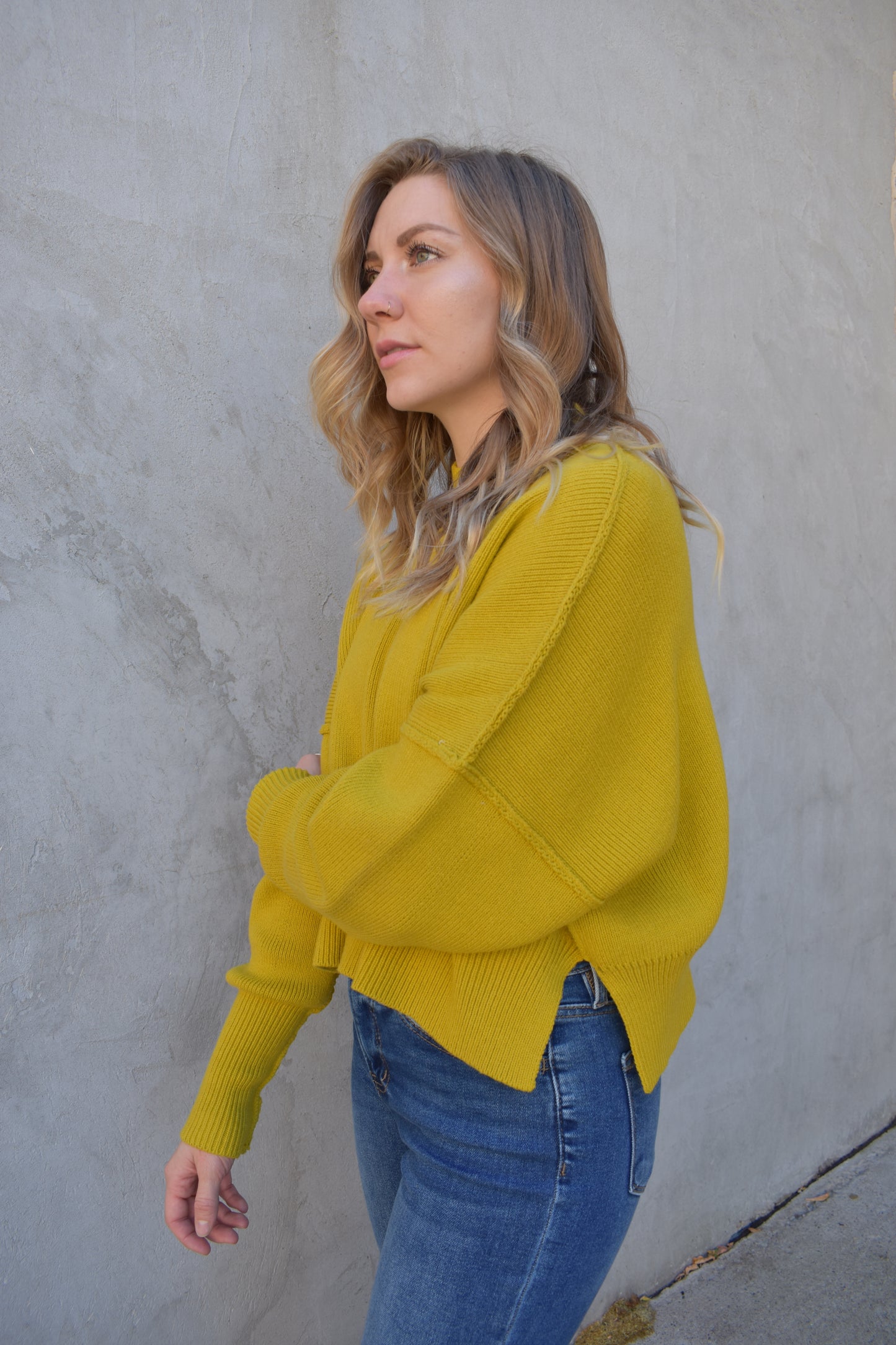 slouchy mock neck sweater with exposed seams, drop shoulders, slightly oversized and slightly cropped, wide ribbed cuffs and hem, split on side of hem