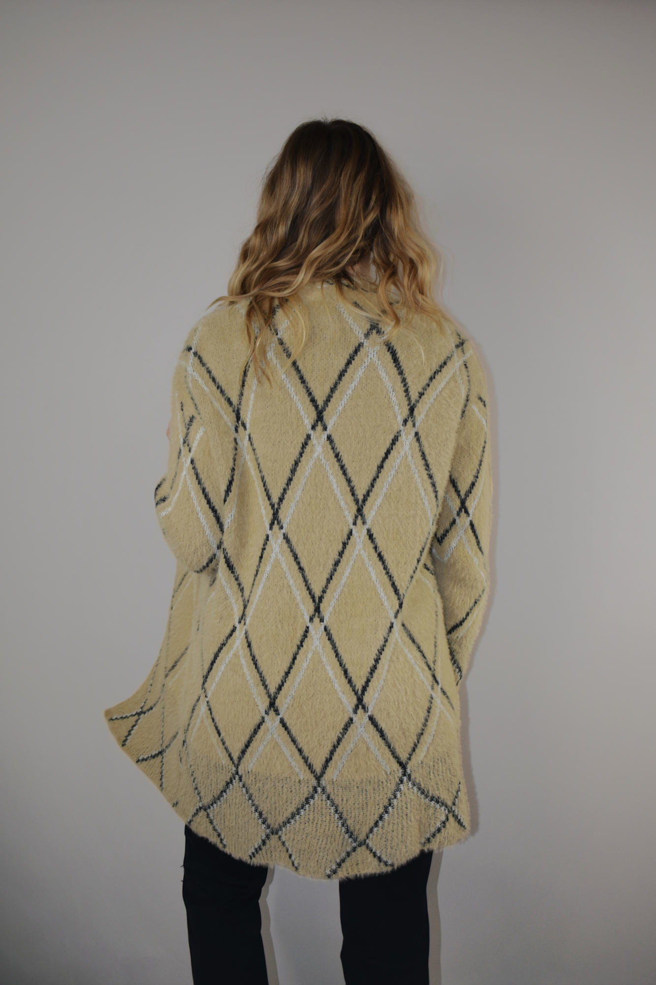 super plush open cardigan with tan background and black and white lined diamond design. hits at mid thigh.