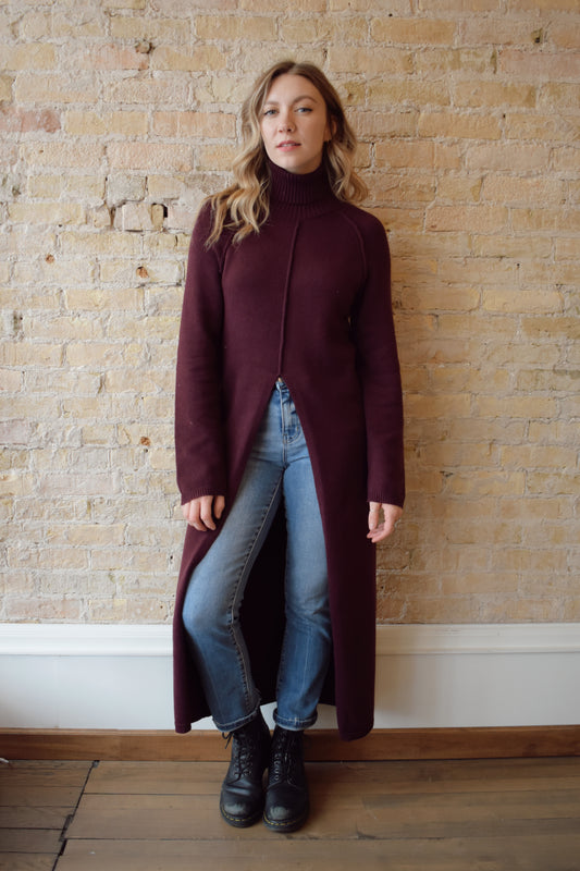 turtleneck tunic sweater dress with split in front up to above waistline, exposed seam detailing down the front and back