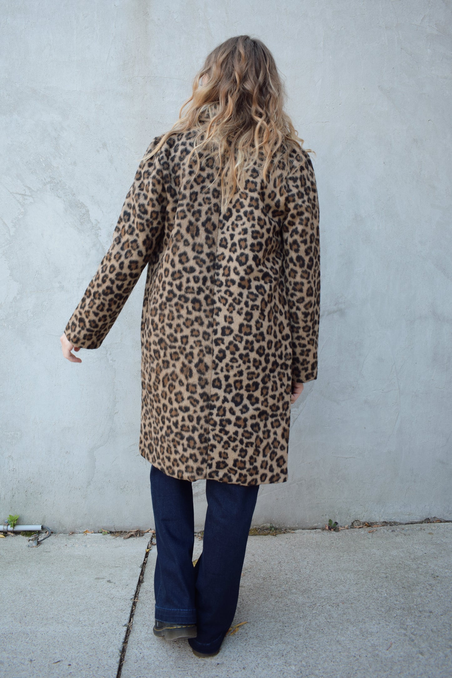 leopard print coat with collar and singular button enclosure has pockets hits just above the knee