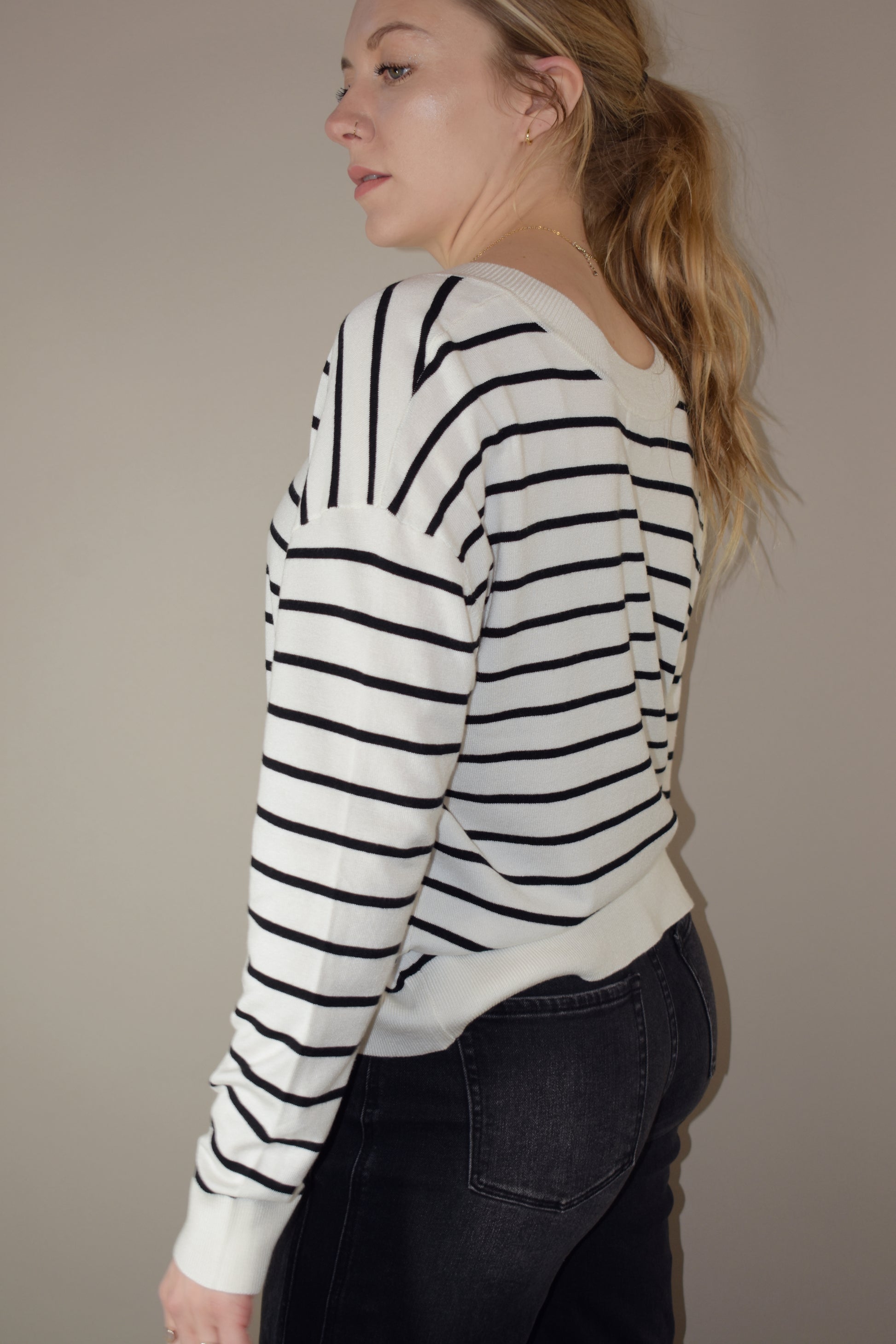 long sleeve full length v neck light weight sweater with horizontal black stripes, solid white hem, loose fit, drop shoulders, super soft.