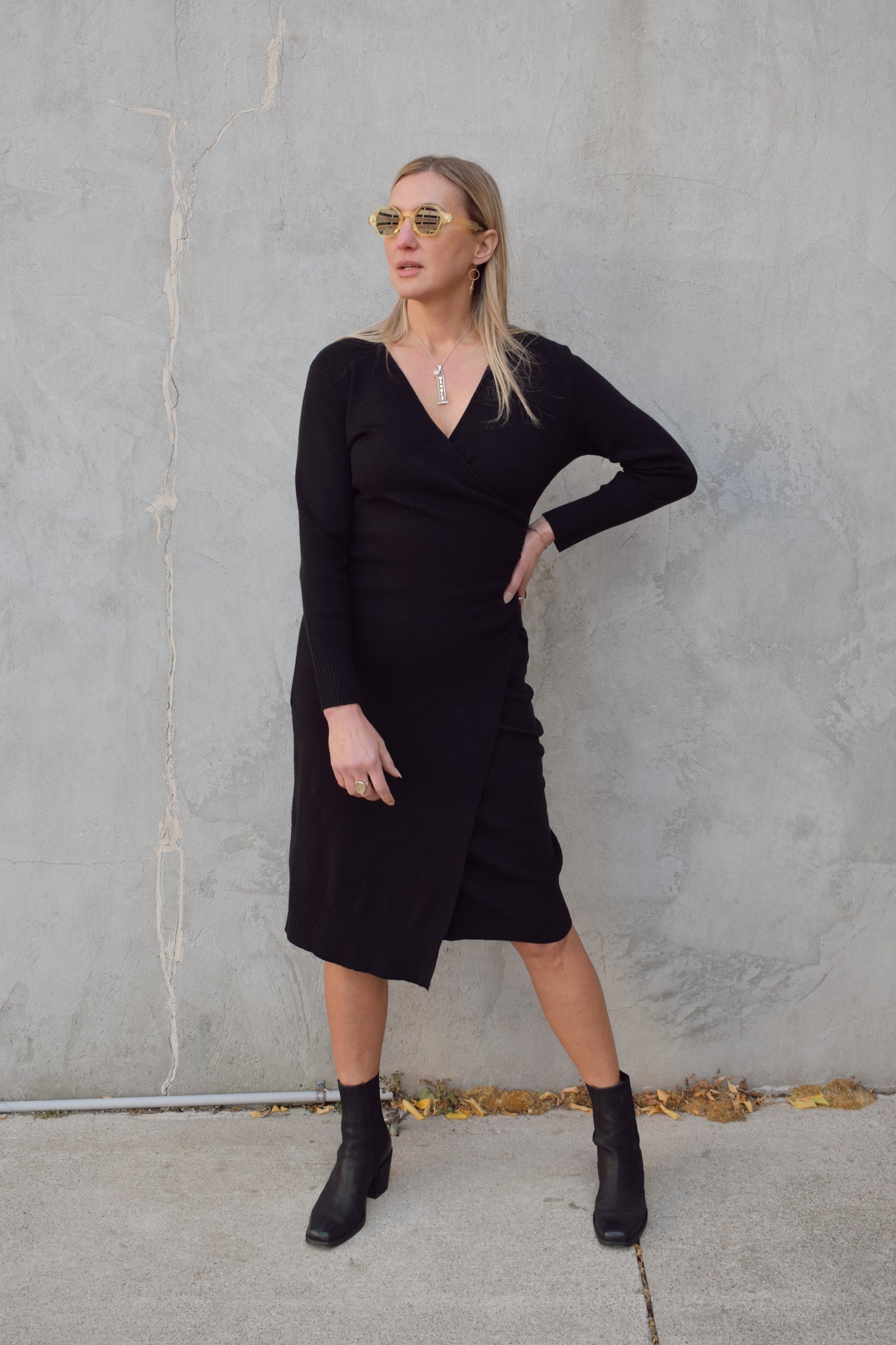 long sleeve black midi wrap dress with v neck and ruching detail on side of bodice, surplice hem, thick material, fitted.