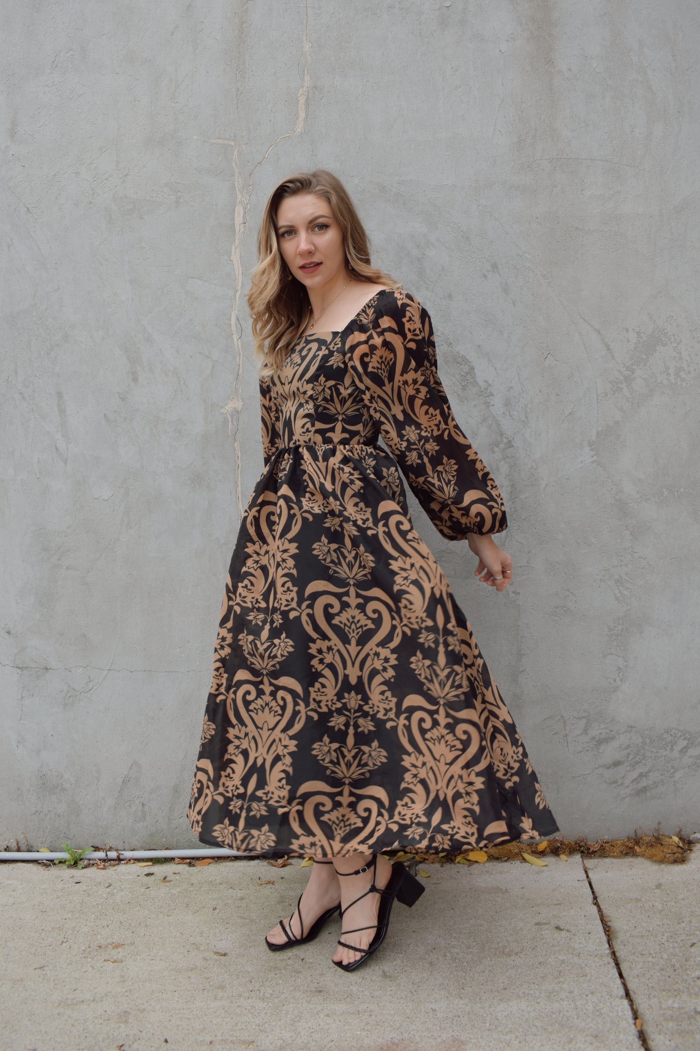 black and dark taupe dark bohemian print midi dress with square neckline front and back, balloon sleeves, flowy skirt, and zip back enclosure