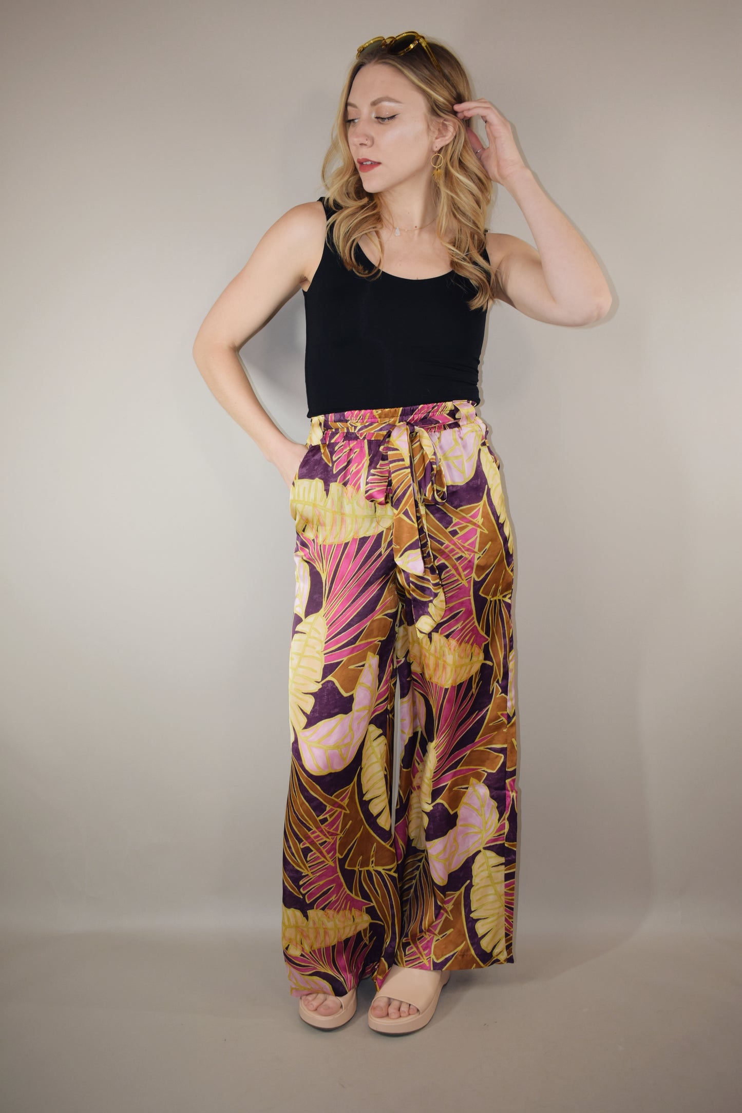 satin wide leg pants high waisted full length with elastic on back of waistband satin sash waist tie has beltloops and pockets tropical print with magenta cream and blush tones