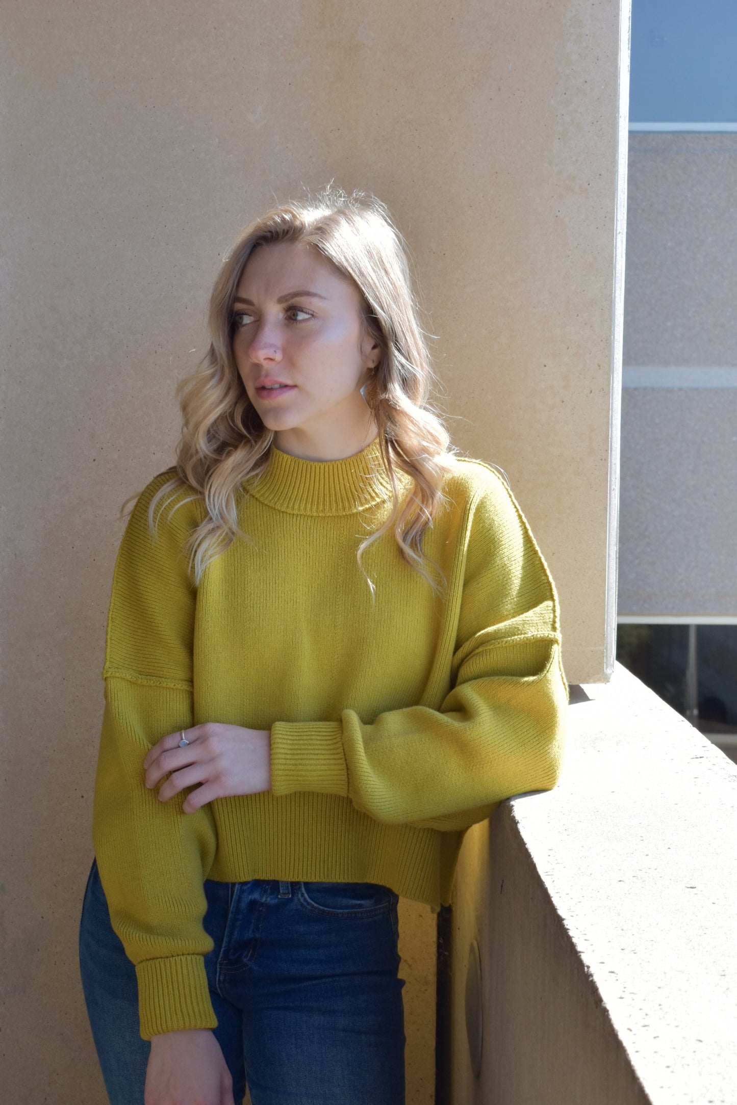 slouchy mock neck sweater with exposed seams, drop shoulders, slightly oversized and slightly cropped, wide ribbed cuffs and hem, split on side of hem