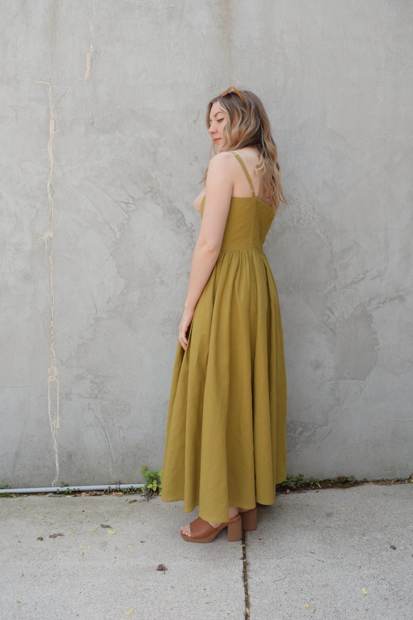 spaghetti strap midi dress with pleats at waistline fitted bodice buttons all down the front that are the same color as the dress, adjustable straps, has pockets, square neckline, smocked panel on back of bodice