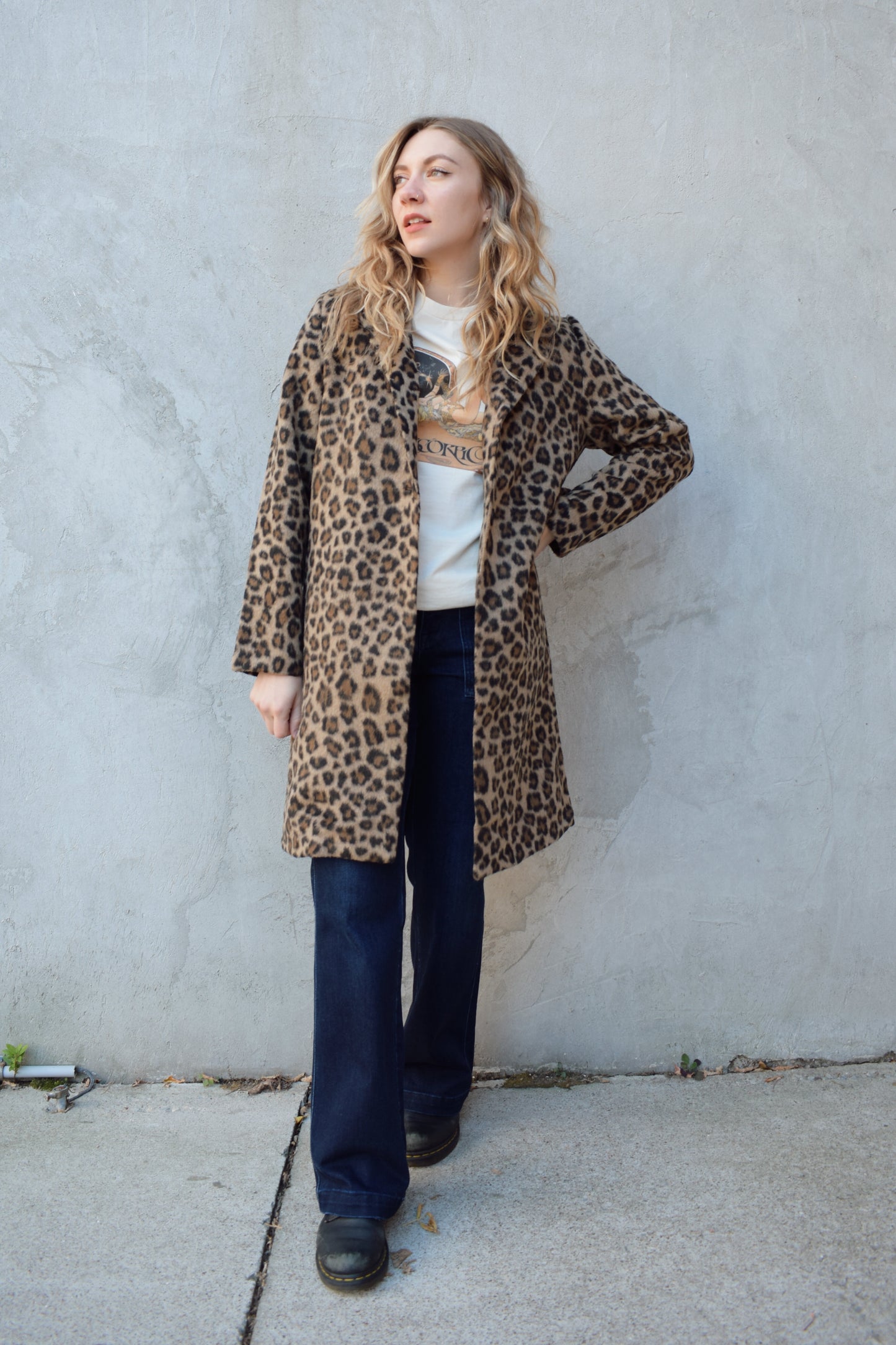 leopard print coat with collar and singular button enclosure has pockets hits just above the knee
