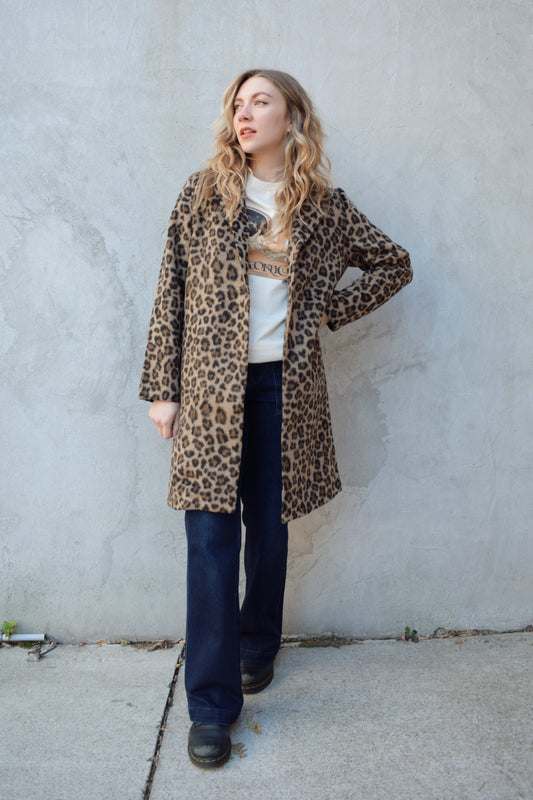 leopard print coat with collar and singular button enclosure has pockets hits just above the knee