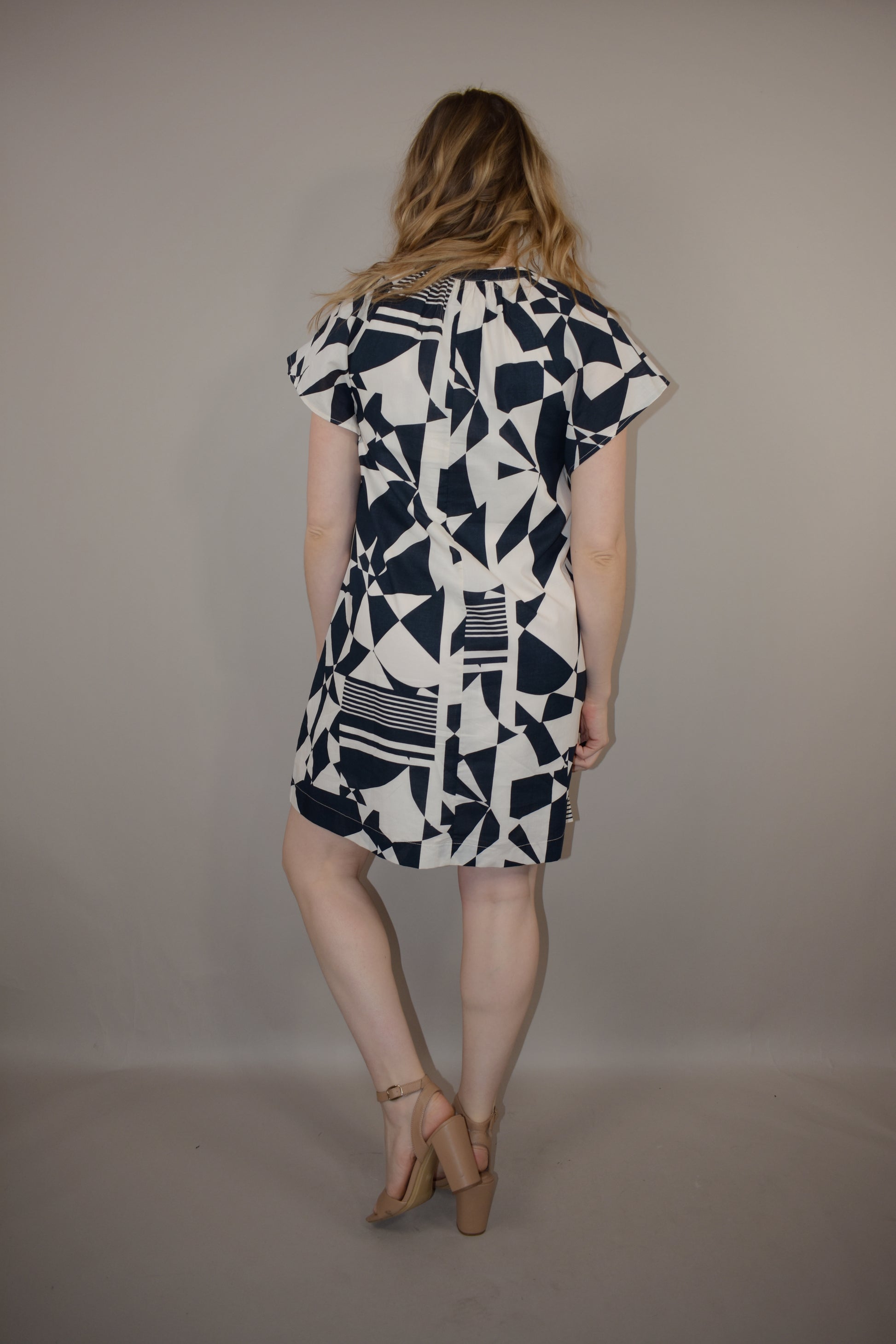 short sleeve loose fitting mini dress with v neck and boxy sleeves with a geometric dark blue pattern on a white background - is lined and has pockets