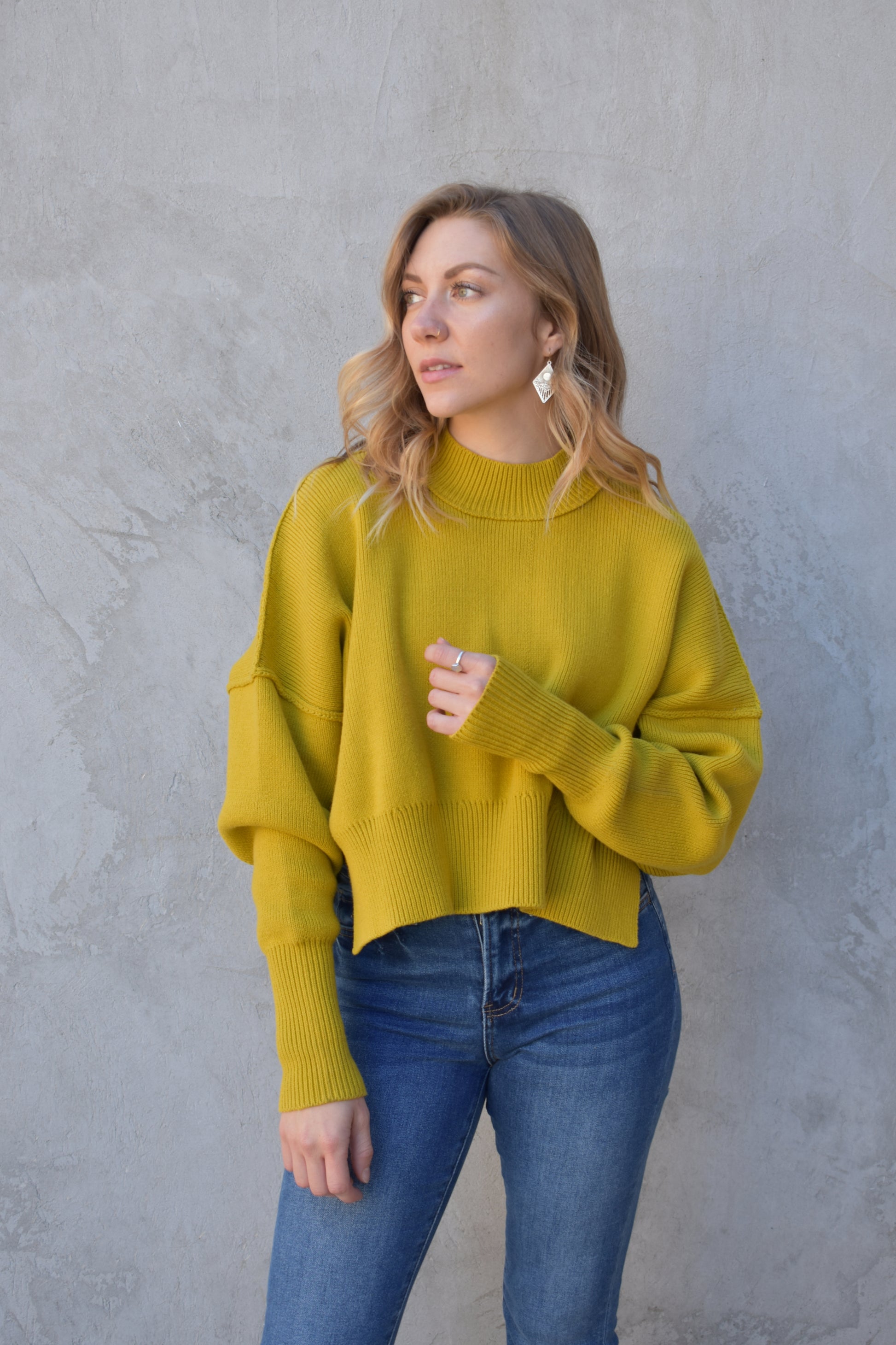 slouchy mock neck sweater with exposed seams, drop shoulders, slightly oversized and slightly cropped, wide ribbed cuffs and hem, split on side of hem