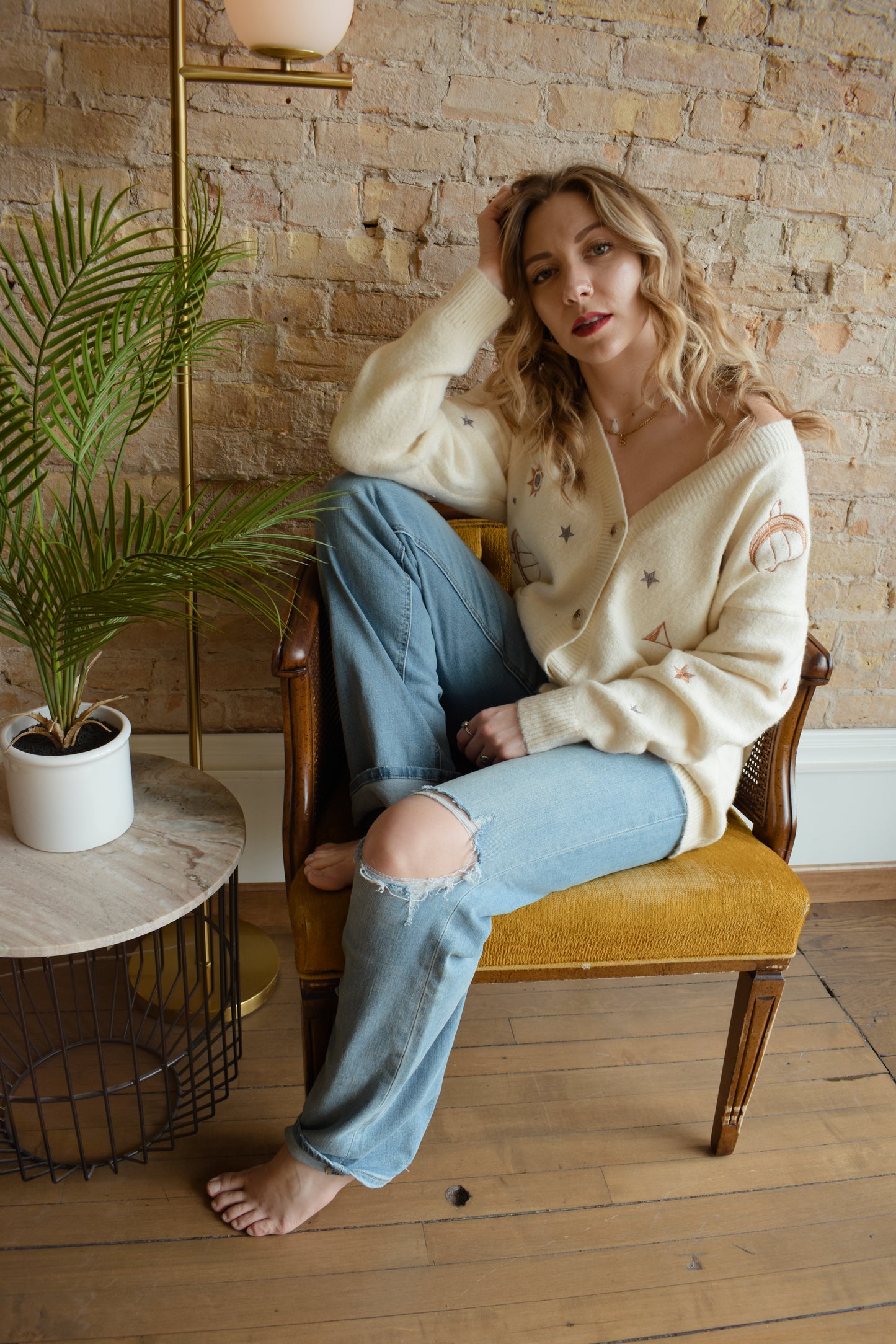 cream slouchy v neck button down cardigan hits just below hips and is embroidered with stars moons and suns has front patch pockets and drop shoulders