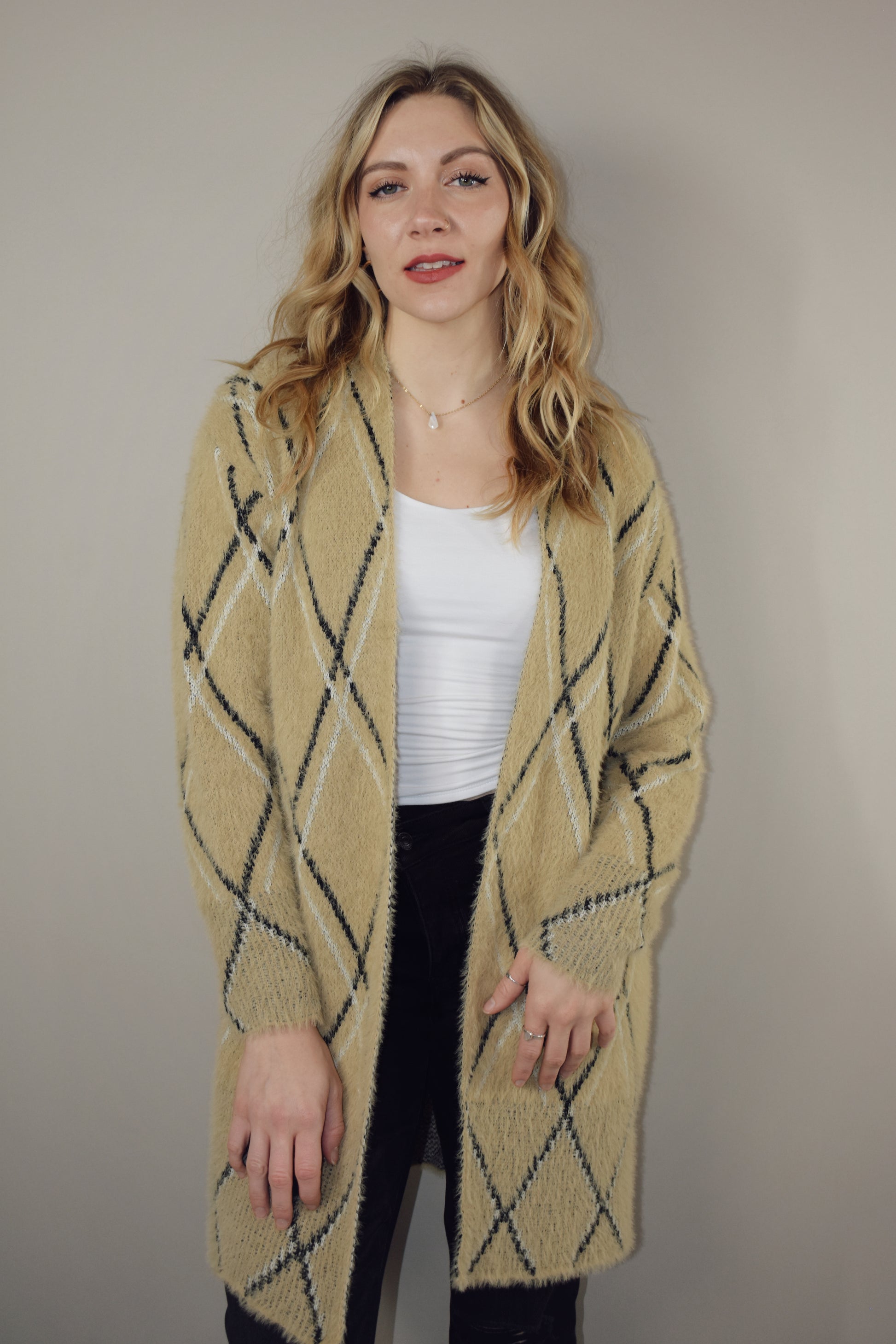 super plush open cardigan with tan background and black and white lined diamond design. hits at mid thigh.