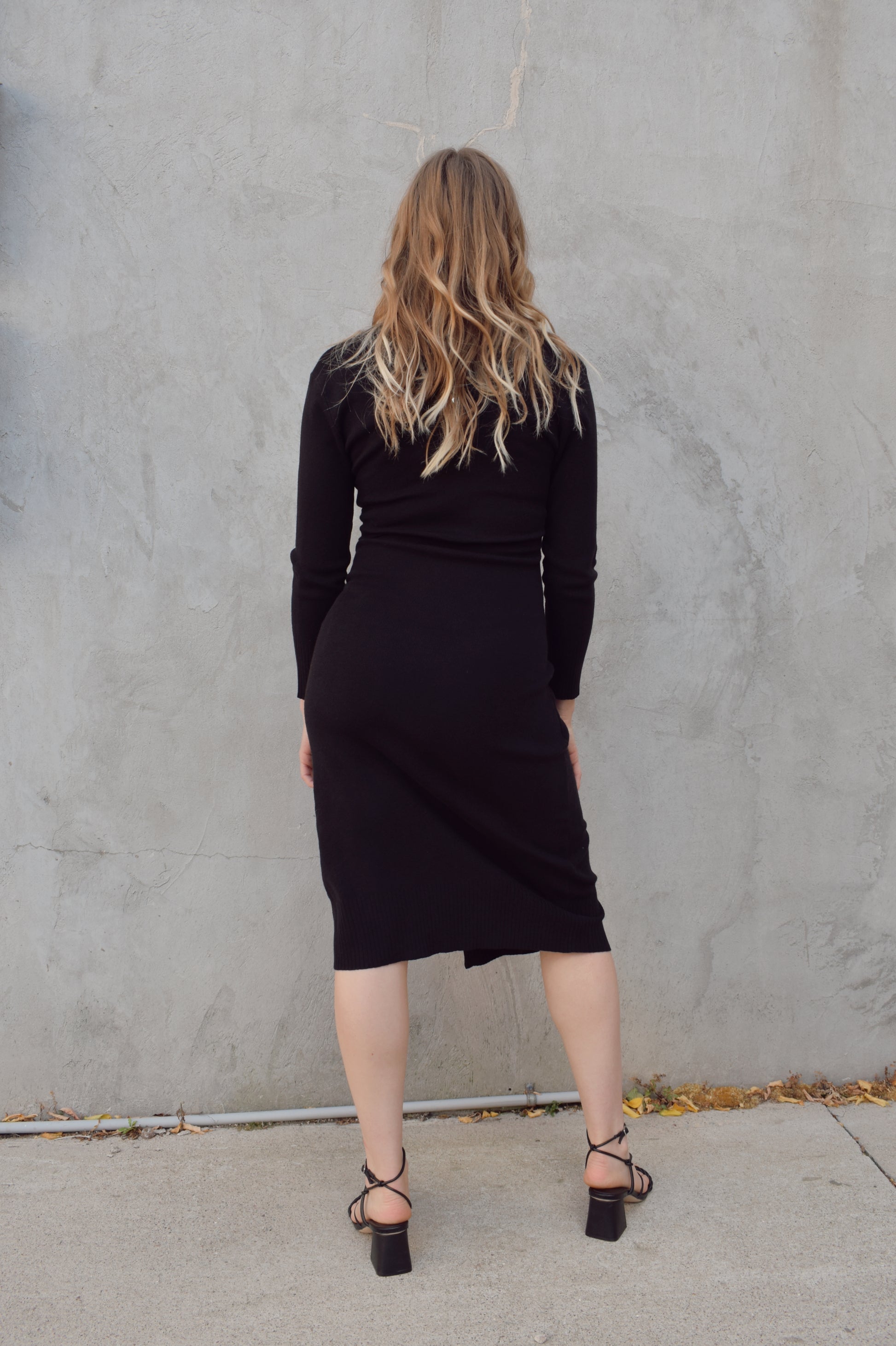 long sleeve black midi wrap dress with v neck and ruching detail on side of bodice, surplice hem, thick material, fitted.