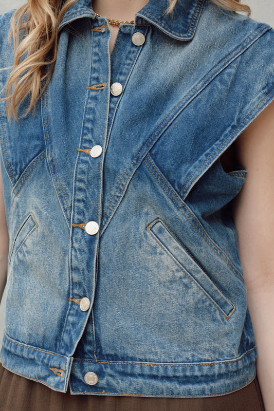denim full length vest medium wash with some lighter wash marks no holes seam details along front side and back has slit pockets front button enclosure and structured shoulders